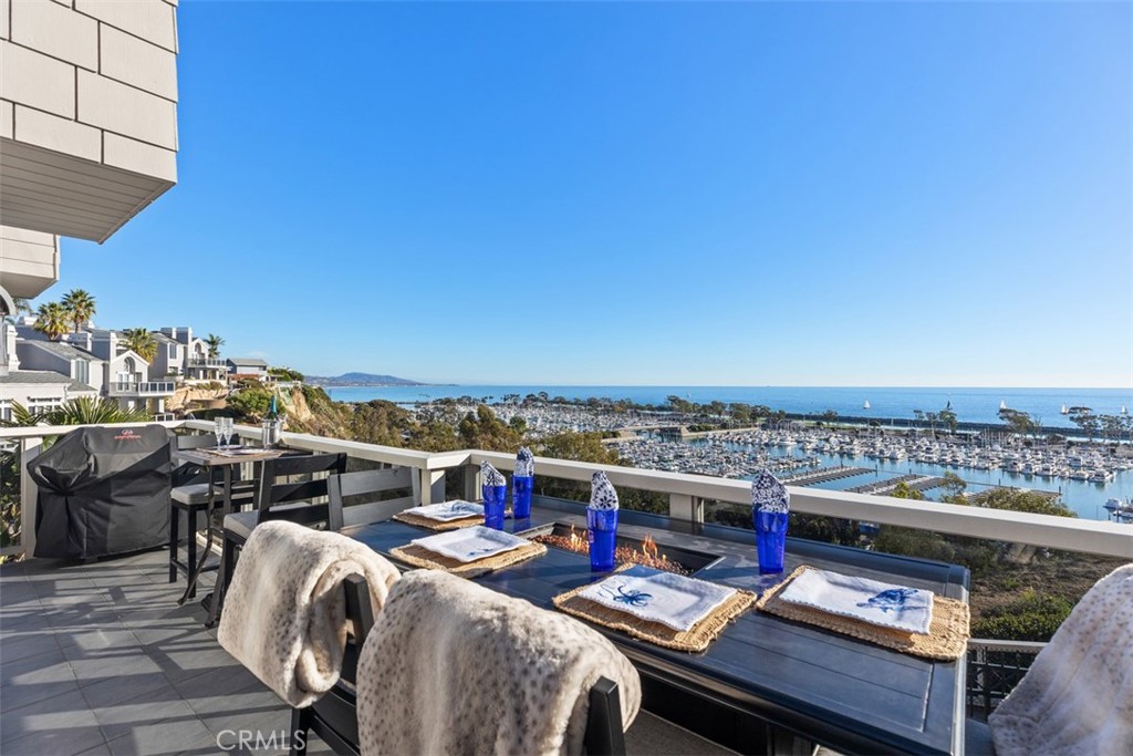 Available October 3rd! Set high above Dana Point Harbor, this rare residence offers an unparalleled lifestyle in the exclusive Admiralty community. With breathtaking panoramic views of the ocean, harbor, and whitewater waves, this beautifully upgraded 2-bedroom, 3-bathroom home spans 2,765 square feet, with an optional third sleeping area or den. Upon entry through double doors, the main floor opens to a wall of windows and doors showcasing sweeping ocean vistas, framed by a striking stacked stone fireplace that reaches up to vaulted, beamed ceilings. The open layout connects the living area to a chef’s kitchen, equipped with top-tier appliances like a Thermador double oven and cooktop, plus Subzero fridge and freezer—ideal for culinary pursuits. An oceanfront terrace extends from the kitchen and living area, complete with a firepit for outdoor dining and taking in the cool coastal breeze. The main level also hosts a secondary suite with a walk-in closet and a luxurious bathroom featuring a dual-sink vanity and walk-in shower. Descending to the lower level, you'll find the primary suite, a private sanctuary with its own terrace and sweeping harbor views. This spacious retreat includes a dual-sided fireplace, perfect for enjoying from both the bed and the jacuzzi tub. The ensuite bathroom boasts dual vanities, an oversized shower with a dressing area, a jacuzzi tub, and a generous walk-in closet with a secure safe. A private sauna adds an extra layer of indulgence. The lower level also includes a flexible den area, ideal as a third bedroom for guests or additional lounging space. This property is only moments away from downtown Dana Point’s shops, dining, harbor, scenic coastal trails, and world-renowned beaches. Available for both short and long-term rental, this home epitomizes Southern California’s luxurious coastal lifestyle.