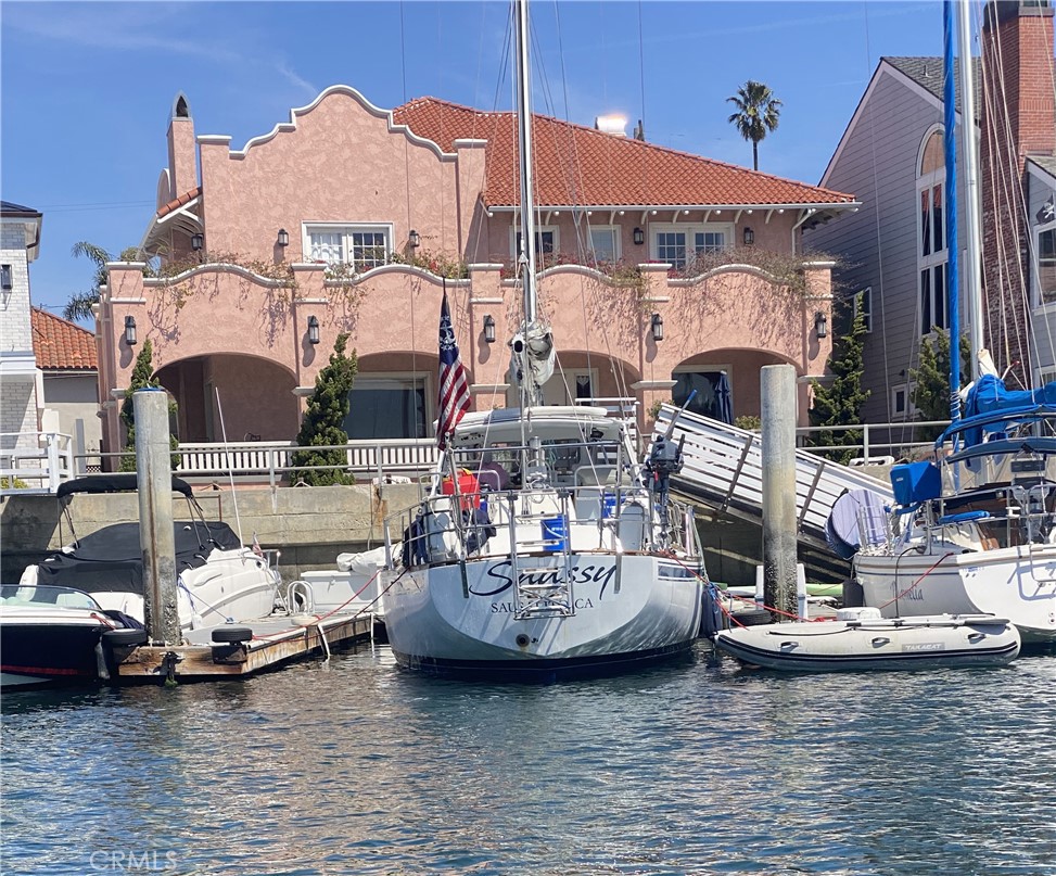 For those people that appreciate Naples Island and it's amazing history of this special community, this is a One of a Kind and once in a lifetime opportunity to own a piece of our history. The "Pink Palace" on the Alamitos Bay waterfront, spanning two full lots, was built in 1907 by Arthur M. Parsons for his son, C.M.Parsons. It has been a "Landmark" home for Naples Island since it's construction. The special home was designed in the "Mission Revival" style which was new to Naples and is one of the first six homes ever constructed in Naples. The interior reflects the Old World values in it's use of beautiful mahogany wood for the formal living rooms, formal dining room and den and bar room. The open floor plan was designed for entertaining, as all the downstairs rooms are adjacent to the formal entry. This classic home has stood the test of time and is still one of the most recognized and treasured homes of Naples. Moving up the mahogany and oak stairs, there is an open landing with three waterfront bedrooms, as well as, two in the rear of the house, two with on suite bathrooms and an additional guest bath, as well. This home is full of character and has been fully restored to it's original natural beauty. This homes consists of three open water slips, two of which can accommodate up to a 50 foot vessel. Enjoy the Indoor/Outdoor Lifestyle of this truly spectacular masterpiece home and location.