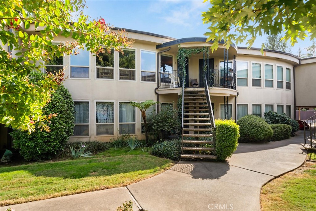 This turnkey, beautifully-maintained second story condominium in a quiet cul-de-sac, offers panoramic views of trees, distant foothills and a serene courtyard. The bright, inviting living room, enhanced by a wall of windows flood the room with natural light. The home features a spacious floor plan with two bedrooms and two bathrooms. The primary suite boasts a walk-in closet with full bathroom, and a luxurious soaking tub in the guest bathroom is for your relaxation. Features include dual-pane windows, central heating and air-conditioning, custom-made insulating blinds on all six ceiling-to-floor windows, wood and laminate flooring, and a newer water heater. The modern kitchen is perfect for any home chef, with a gas stove, dishwasher, refrigerator and a cozy nook ideal for dining. Located at the end of a peaceful cul-de-sac, this complex offers privacy and tranquility, and you can enjoy access to the in-ground swimming pool, covered parking, extra storage, a bike room, and an onsite laundry facility. Situated in desirable north Chico, you are just moments away from schools, a shopping center, including Trader Joe’s, dining, banking, the theater, and more. This home truly has it all and is move-in ready!