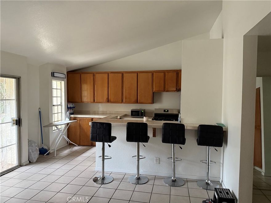 Welcome to your charming California retreat in the heart of Paramount! 2 Bedrooms, 2 Baths Condo, enter the gated community and park in your assigned parking #6 near your unit, Go up the stairs and enter the Open floorplan with high ceilings. You'll enjoy 2 Balconies (One exiting the living room and the other exiting the Master Bedroom).   Ceramic tiles in Living room and kitchen and laminated floors in bedrooms. The kitchen has a Bar-Counter with seating space for 4 stools and In-Unit washer-Dryer combo in closet. Fireplace in the livingroom.  Assigned Space for 2 car tandem parkings. Close to park. Low HOA