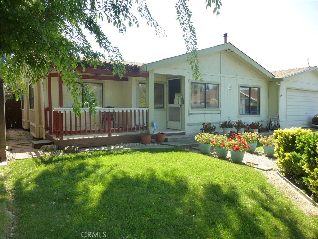 Large 2 bedroom, 2 bath manufactured home with a 10X24 bump out, 2 car garage. Storage shed in the back yard, two covered porches.
Front porch looks onto the spacious green area near the club house. The club house has a pool and a hot tub.