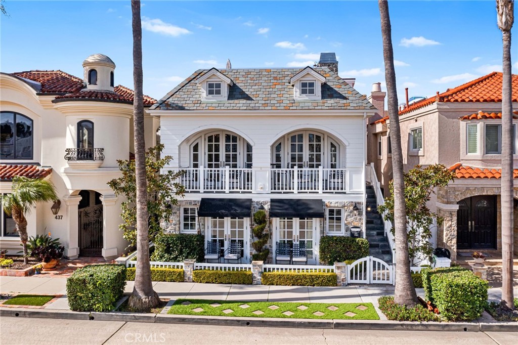 Nestled in the heart of vibrant Peninsula Point, 441 Seville offers an exquisite blend of classic charm and coastal luxury. Just steps from the beach and world-famous Wedge surf spot, this stunning residence boasts an elegant facade with lush landscaping that invites you into a world of comfort and sophistication.
This meticulously maintained home offers 5 bedrooms, 7 bathrooms, custom millwork, magnificent vaulted and beamed ceilings, bespoke details throughout, and panoramic views of the Peninsula. Move right into this fully furnished and picture-perfect estate. The gourmet chef’s kitchen and living room create a lavish sanctuary where indoor opulence merges with outdoor tranquility seamlessly through multiple gorgeous French doors that invite you to a spacious front Veranda. This main level also features the primary suite that is tucked away with a fully customized spa like bath with dual sinks, soaking tub, separate shower and two large walk-in closets. Make your way downstairs to find four additional generously sized bedrooms, four guest baths, and a washroom. You’ll also find a three-car garage with epoxy floors and plenty of storage for bikes, beach gear, etc. Take the three-stop elevator to the upper floor that features a media room, guest bath, and an incredible expansive rooftop deck with a fireplace, built-in BBQ, and wet bar. The perfect space for entertaining family and friends, enjoying a beautiful sunset, and living what the Coastal California lifestyle has to offer. This home has it all!