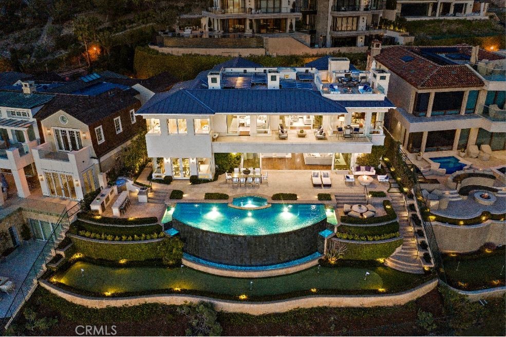 23 Beach View Avenue introduces luxurious influences of the Caribbean to Southern California and is inarguably one of the finest homes in the oceanfront enclave of The Strand at Headlands. The estate's premium homesite sits ocean side proud and, at 107 feet, boasts one of the community's widest ocean frontages. Exquisitely designed to capture sapphire blue seas and color-soaked sunsets at every turn. Upon entry, you are met with breathtaking ocean views stretching along the coastline and out to Catalina Island and beyond. The home's island inspiration blends indoor and outdoor areas with thoughtfully designed natural-light infused living spaces. The entry-level entertainment areas, which include, an expansive great room, a gourmet kitchen, and formal dining room, all flow effortlessly into each other. The owner's retreat includes a luxurious master suite, an executive office, a den with fireplace, an auxiliary kitchen and a private ocean view veranda. The 5 additional bedrooms are ensuite. Treat friends & family to private screenings under the stars in your 10-seat home theater w/terraced full reclining leather seats or share wine from your 1,000 bottle wine cellar and adjacent tasting room. Further amenities include: Full Home Automation, 4-stop elevator, 8-car subterranean parking, panoramic rooftop deck w/fireplace and outdoor kitchen, 48 Solar panels w/two Tesla energy storage batteries, expansive main level deck with infinity-edge pool and spa, and a 5-hole putting green