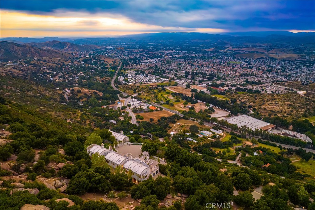 OVERLOOKING ALL OF SIMI VALLEY SEEN ASIDE THE 118 FREEWAY & ROCKY PEAK RD ETCHED OUT OF THE HILLSIDE IS THIS PRESTIGIOUS GATED ESTATE RESTING ON OVER 111 ACRES AND READY TO BE YOURS! CURRENTLY IS A 8,212 SQFT MAIN HOUSE BOASTING 3BR 7BA, WINE CELLAR, LIBRARY WITH CUSTOM SHELVING A SLIDING LADDER, OFFICE, MEDIA /SCREENING ROOM, INFINITY POOL & GYM. GUEST HOUSE HAS 2BR 2BA AND OVER 2,000 SQFT. IMPECCABLE VIEWS FROM ALL SIDES OF THIS PROPERTY. COMPLETELY SECLUDED & PRIVATE WITH CUSTOM STEEL AND GLASS GATE MATCHING ITS UNIQUE CONSTRUCTION MATERIAL. AMAZING PROPERTY AND TRULY A MUST SEE TO APPRECIATE