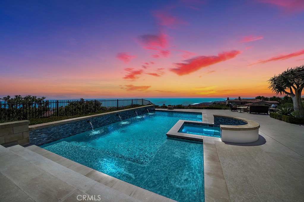 Perched on a private front row 22,000 SF premium hilltop lot with sweeping panoramic views to Catalina and beyond, this captivating and custom remodeled Newport Coast Crystal Cove Estate showcases exceptional style and modern amenities. The golden Southern California sunsets can be admired from nearly every room in this ultra-exclusive home that just completed a 2-year top-to-bottom remodel including the exterior grounds, pool/spa and hardscape. This exclusive offering boasts every desired amenity in 8200 SF of interior living space from an expansive gourmet kitchen to the premium sound home theater to the backyard resort with unobstructed views from Dana Point to Palos Verdes. Four incredible bedrooms (options for 2 additional) include an expansive primary suite with stellar views of the mountains and the sea, creating the ideal respite in your personal paradise. Each space has been thoughtfully designed using only the finest in high-end materials. No stone was left unturned in this home, from luxury and comfort to flexible living. A large casita separate from the main house allows for maximum privacy for guests. Access the 2nd level from the gorgeous circular stairwell with its handcrafted wrought iron banister, or take the elevator. This home affords endless amenities: among them: a 1500 bottle temp controlled wine room, gorgeous limestone flooring, Quartzite counters, top-of-the-line appliances, 4 car garage, gardens, and state-of-the-art technology in a “SMART” home.