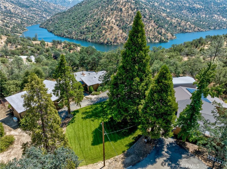 California Spanish Hacienda Style home on Redinger Lake!!!! Located on 12.51AC with vast incredible vista views of the lake, mountains, and seasonal waterfall! As you enter the gated Hacienda you are in aww of the circular driveway that surrounds a gorgeous lawn with massive cedar trees that accent the adobe style home. As you walk thru the custom door into the home, your eyes will go straight to the large windows that can't help but to captivate you right to the phenomenal deck and exquisite lake views! The pristine home features windows galore, pine cathedral open beam ceilings, skylights, peeled pole supports, slate floors, and a unique floor plan. This home has 2 master bedrooms. The larger master suite is located at the opposite end of the home from the other 2 bedrooms. The main master suite has a charming wood stove and glass doors that lead out into the fairytale back deck with lake views, all while laying in bed. The master bath could not be more charming, owners dug up the slate floors themselves out in Mariposa. Plus it has 2 basins with a pine ceiling and a glass atrium looking out into a mystical garden area! The kitchen is just as fabulous with windows looking out to the lake and new appliances. To make sure you are always comfortable inside the home there are 2 mini split units and 3 hot water heaters and one is on demand!!! There is not enough to say about the deck that has built-in benches, multi-level, and views of the lake that you never want to leave! Do not forget the massive garage has a shop, bonus room, and an attached van storage room. I forgot to mention the insane well that produces over 100gl/min. A property like this does not come around often! Perfect for all year round or as a 2nd home or AirBnB!!!!!