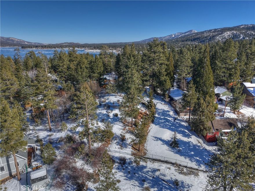 A Serene & Spacious Flag Lot in the Heart of Big Bear Lake WITH *OWNER FINANCING AVAILABLE*  Tucked away on a charming flag lot, just one block from the shimmering waters of Big Bear Lake, this 24,150-square-foot property offers a rare combination of space, privacy, and natural beauty.  Enveloped by mature trees and fully fenced, this over half-acre retreat provides a peaceful escape while being centrally located to all the best that Big Bear has to offer.



Imagine waking up to the possibility of lake views just beyond the treetops, with sunlight filtering through the pines and crisp mountain air greeting you each morning. Whether you dream of building a cozy weekend getaway or a stunning full-time residence, this property is a blank canvas for your vision—a place where thoughtful design and nature can come together in perfect harmony.



With a water meter already installed, much of the groundwork has been set, allowing you to focus on crafting your ideal retreat. The generous lot size provides ample room for a beautifully designed home, charming garden paths, or even a private outdoor entertaining space—perfect for hosting intimate gatherings under the stars.



Centrally located in Big Bear Lake, this prime piece of land offers the best of both worlds—seclusion and convenience. You’re just moments from the lake’s edge, marinas, hiking trails, and the vibrant Village, where you’ll find wonderful dining, shopping, and seasonal festivities.



A rare and exceptional opportunity, this lovely property invites you to create something truly special—a place to slow down, embrace nature, and make lasting memories.
