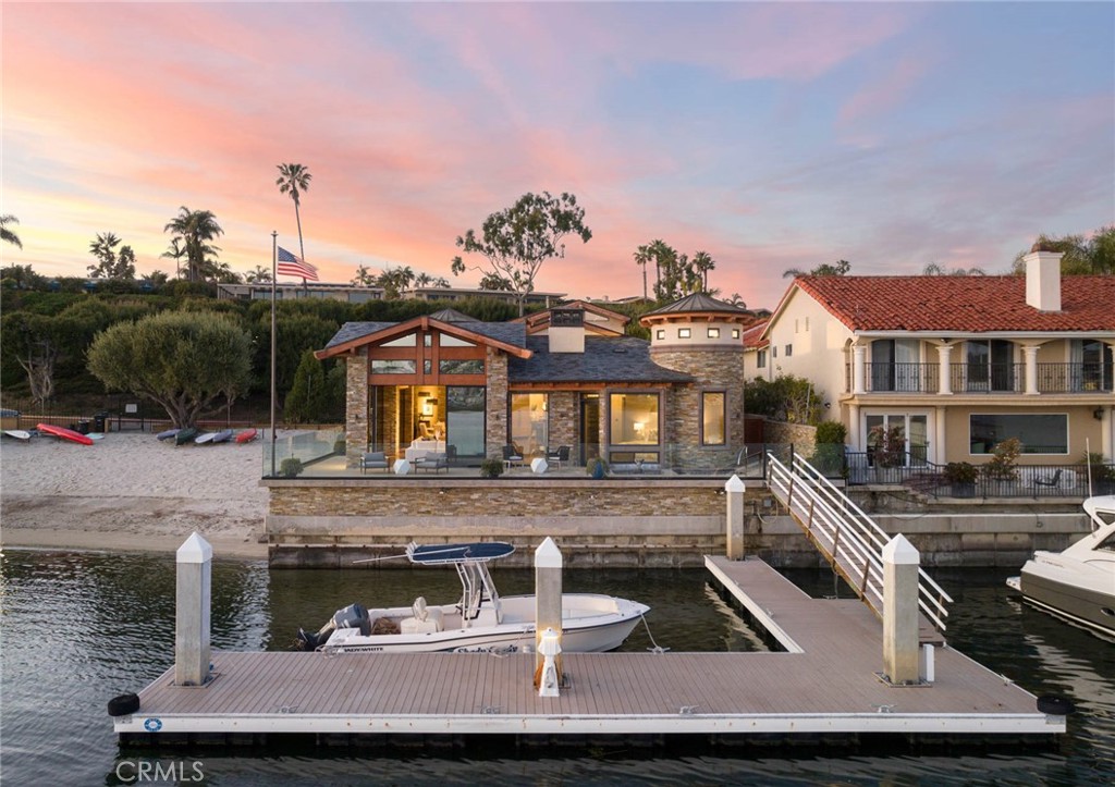 Discover this exceptional bay front residence in the sought-after Dover Shores neighborhood of Newport Beach, masterfully constructed in 2013 by RDM General Contractors. Spanning over 4,300 square feet, this stunning home features 4 bedroom suites, 4.5 baths, a one of a kind office, and a secure dock for a boat up to 60+ feet. Showcasing an exceptional blend of the finest hardwoods and natural stone, this luxurious property stands as a testament to meticulous attention to detail and unparalleled craftsmanship. The main level showcases a spacious great room with vaulted ceilings, over-sized picture windows, and sliding door systems, all oriented towards breathtaking views of the private community beach, Back Bay, and Fashion Island. The primary suite boasts a cozy fireplace, dual closets, and a luxurious bath with steam shower, soaking tub, and direct hot tub access. The chef's kitchen comes fully equipped with state-of-the-art appliances, a custom eat-up island, and walk-in pantry. Three secondary bedroom suites provide ample space for family and guests (two located upstairs with elevator access). Don't miss this rare opportunity to own one of the bay's best-kept secrets.
Property listed for comp purposes only