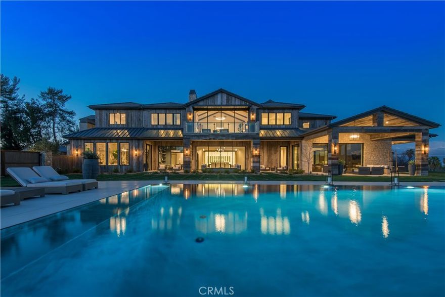 Simply spectacular, one of a kind estate sited on 7.43 lushly landscaped acres, highlighted by panoramic views. Enter through private gates, cross the storybook bridge, pass the picturesque barn, and take the gently winding driveway to the top where you'll be welcomed by this magnificent estate. Step through the custom iron & glass door into a 24' tall entry, where 14,678 square feet of superb quality and refined elegance awaits. Highlights include a state of the art chef's kitchen that flows into the great room with open beam ceiling, fireplace and sliding walls of glass, that open to the adjoining outdoor living room, a formal dining room with adjacent Onyx wet bar and glass encased wine display, luxurious home theater with upholstered walls, large game room with bar and snack center, glass surrounded gym with steam shower, private study, sunny bonus room, and 6 en suite bedrooms, including the spectacular primary suite with dual, all stone baths, walk-out view balcony, and enormous custom closets. The showplace grounds feature an approx. 65' long zero edge pool & spa, two complete barbecue centers, two 3-par golf holes, a championship tennis court, a sand volleyball court, over 1/2 mile of private golf cart trails, 1,836' of covered patios, a 1,600' barn, two fire pits, multiple entertaining areas, and garages for 11 cars! Additional amenities include European Oak floors, decorator lighting fixtures, elevator, Savant smart home system with Lutron lighting, fountains & more. This is truly a one-of-a-kind estate, sited on the largest lot in the City of Hidden Hills. Don't miss it!