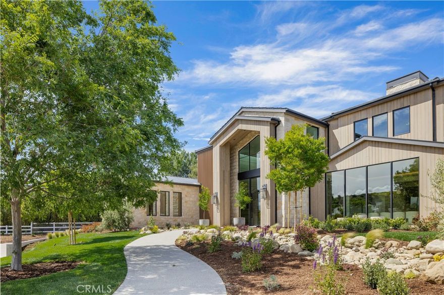 Welcome to "The Ridge at Hidden Hills". This new, absolutely spectacular, one-of-a-kind estate is nestled at the end of a quiet cul de sac and is sited on a beautiful 1.77 acre view lot. Step through the custom 12’ glass pivot door and enter into a world of luxury, elegance, and quality. Bathed in natural light, and spanning 21,670 square feet, this home exemplifies the essence of the relaxed, indoor/outdoor California lifestyle. Highlights of the spacious open floor plan include a gorgeous, three level floating staircase, stellar, restaurant quality chef’s kitchen (and prep kitchen), entertainer’s center island with counter seating, and big breakfast room, all open to the large family room with motorized, sliding walls of glass, two-sided fireplace, and adjoining living room with lounge and seating bar. Additional amenities include a formal dining room with refrigerated wine wall, adjoining butler's pantry, and a full catering kitchen, plus a large private office with full wall windows, a stunning home theater with fabric covered acoustic sound walls, and wonderful gym & spa complete with massage room, steam shower & sauna. There are six generous en suite bedrooms, four upstairs and two on the main floor, all serviced by an elevator. The superb primary suite offers a sitting area, fireplace, deluxe bath with dual showers and big soaking tub, enormous, room sized custom closets, and a large private balcony showcasing the expansive pastoral views. One of the two downstairs suites is a second primary suite with a soaking tub, covered patio, and its own private entrance. The basement space is a world of its own with a huge game room/lounge, a two lane bowling alley, and garages for 10 cars, showcased by gleaming epoxy floors, plus there's an additional 4 car garage on the main level. The spacious grounds include a sparkling, zero edge infinity pool & spa, three covered patios complete with a full barbecue center, two fireplaces, a powder bath, outdoor bath & shower, and expansive grass lawns. There are also plans for a guest house. This trophy property is located on one of the finest streets in all of Hidden Hills, and close to highly regarded public & private schools, and The Commons shopping center.