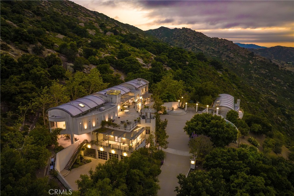 *** PRICE IMPROVEMENT *** Experience the awe-inspiring allure of this property located in the Santa Susana Knolls, boasting a captivating architectural masterpiece. Designed by the renowned David C. Martin, AIA of A.C. Martin Partners, this residential sculpture stands as a testament to power & drama. Nestled within an expansive landscape encompassing approximately 111+/- acres, this property is a feast for the senses. Enchanted by the iconic natural surroundings, featuring a striking display of rare plantings, majestic rock formations & waterfalls. With its undeniable beauty, this radiant residence transcends traditional expectations & leaves a lasting impression. The structure itself spans over 10,000 square feet, showcasing a harmonious blend of steel and glass. Indulge in the luxury of space with 5 bedrooms, 9 bathrooms, including an opulent master suite, library with floor to ceiling shelves, office, gym, media/bonus room, elevator & impressive wine cellar. The chef's kitchen boasts not just one, but two expansive islands, perfect for culinary enthusiasts with commercial appliances. Sunlight bathes the public rooms, creating an atmosphere of warmth & serenity. Step outside onto the expansive stone terraces & marvel at the breathtaking views of mountains & valleys that stretch as far as the eye can see. Additional features of this extraordinary estate include a self-contained guesthouse with two bedrooms, an infinity edge swimming pool & tranquil meditation gardens. Immerse yourself in the modern luxury that this property offers, all within a magical setting that feels worlds away, yet conveniently located just 30 minutes from the Westside & minutes from Porter Ranch. This offering is truly a rare & remarkable opportunity.