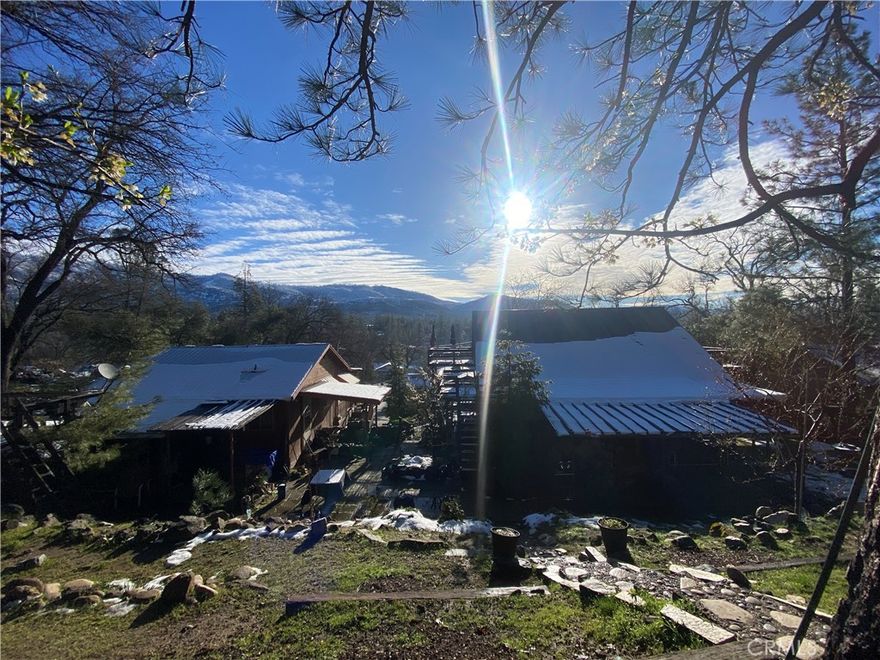 TWO homes conveniently located in charming downtown North Fork. The main home is a 3 bedroom 2 bathroom mountain cabin. The driveway leads to a single car garage with a workshop area. Follow the stairs up to the second level where you'll find the main living quarters with a living room, kitchen, guest bathroom and primary bedroom with attached bathroom. Through the kitchen you'll find the laundry room and doors leading to the backyard with a covered patio area. Upstairs from the main living area you'll find 2 bedrooms, one of which has been converted into an open den/loft area. Doors lead out to upper decks on each side of the home allowing you to take in the stunning mountain views! The guest house is a 1 bedroom, 1 bathroom detached home with a single car garage. The views here are unbeatable and the location is fantastic with just a 45 minute drive to Fresno, 30 minute drive to the entrance of Yosemite National park, 10 minutes to Bass Lake and less than a 2 minute walk to North Fork's downtown shopping and eateries. Central heating and air in both houses. The guest house currently has reputable tenants which have helped to maintain the home and have paid on time each month. They would love to stay if possible, giving you instant income and a trustworthy caretaker. Call your favorite realtor today to schedule a showing!