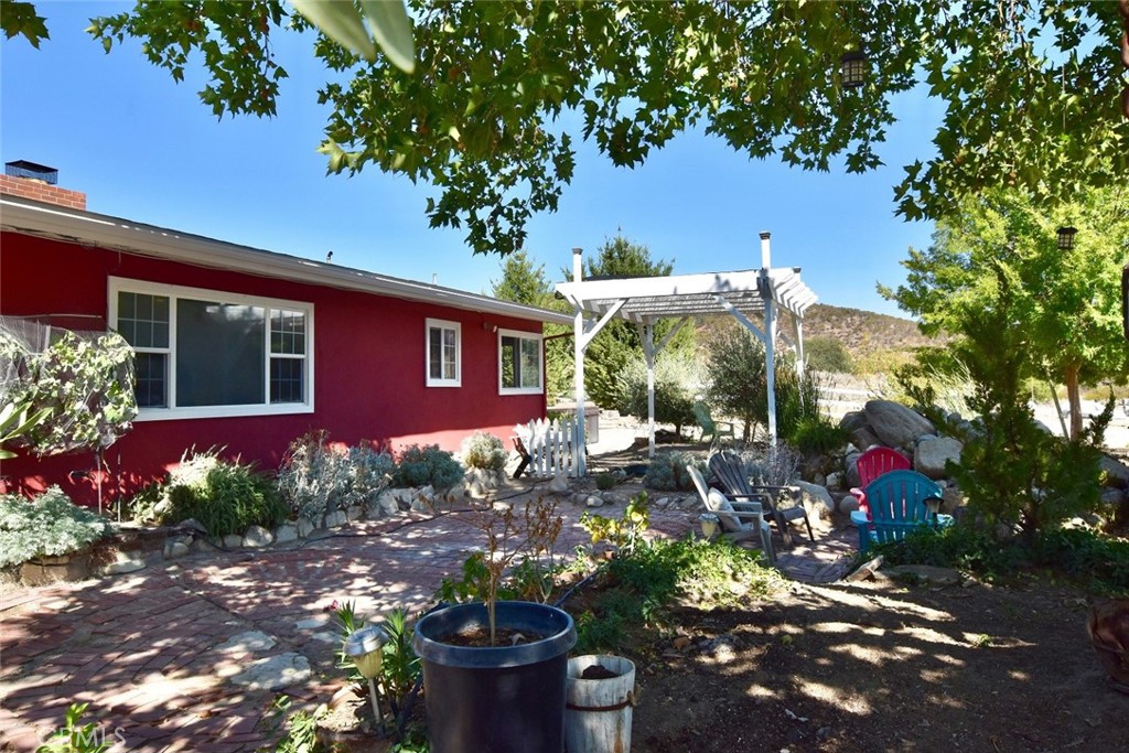 Live, work & play! The possibilities are endless on this sustainable ranch w/heavy commercial zoning! Charming 4br/2ba home on 6 AC. Incls 3,200± sq ft insulated warehouse w/apt. & mezzanine. Commercial greenhouse w/power & water + solar. 2nd greenhouse w/work stations create perfect environment for delicate plants & processing produce. Oversized pole barn & open bay garage w/lighted lot designed for RV & Boat parking. This would also make a great horse facility w/plenty of flat ground. There is an addtl 1,200± sq ft of covered parking/work bays w/concrete slab + small barn & chicken coop. 25,000 ± sq ft of asphalt + untouched land remaining for more ventures. Kubota tractor included in sale. Catch bass, crappie, carp, blue gill & shad from your own dock or take the boat out in the large pond while sharing space w/resident blue heron, snowy egret & bald eagles. The home is 1,856± sq ft w/a covered porch entry. Features hardwood flrs, dual pane windows, wood beamed & vaulted ceilings, numerous French doors w/covered patios to bring the outdoors in. Mini-split A/C system w/ceiling fans & wonderful wood burning fireplace. Homey kitchen w/oversized pantry & formal dining. Large master w/walk-in closet & spacious new bath. Washer dryer, water softener & solar panels are included. Sturdy carport accommodates personal vehicles. Shangri-La featuring lush landscape lined w/ rustic Carmel stone walls & soothing waterfall into shaded koi pond. Home for many mature koi fish & Rosie, the turtle. Relax in natural bird sanctuary or cozy up to the outdoor fireplace on the brick patio enveloped by bamboo & oaks. Soak in the peaceful setting of the Jacuzzi w/unobstructed views of mountains, sunrises, sunsets & the big night sky. Self-contained 2br apt. situated inside the warehouse has its own electric meter, propane tank & HVAC system. Incls living room, kitchen w/pantry, 2 large bdrms w/walk-in closets & a full bath. On the path to south shore entrance for Lake San Antonio w/paved road & electronic entry gate. Good well w/large water storage tanks. Unique commercial land surrounded by larger ranches just waiting for your new entrepreneurial ideas. Zoning allows for a wide variety of uses incl hotel, motel, restaurant, church, kennels, auto repair, trucking operations, contractor’s yards, cannabis activities & more. A good candidate for vacation rentals, glamp camp & event center. Check with Mo. Co. for specific regulations. Possible 30% down commercial financing.