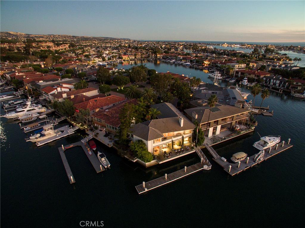 Located on ultra exclusive Linda Isle, this landmark waterfront property defines Newport Beach living at its best. A piece of southern California history, the stunning 5 bedroom, 8 bath estate was built in the 1970's for Robert and Shirlee Guggenheim to accommodate their social and high profile lifestyle. The vantage parcel, on the prestigious western tip of this guard-gated island, makes this home an entertainer's and boater's dream boasting over 105' of water frontage. Its private pier allows for a boat up to 85' in length and is touted as one of the largest individually owned yacht accommodations in the harbor. 88 Linda Isle is the 8th largest home on the island and its spacious lot is in the top 20% of all of the island’s homes. The home features extraordinary unobstructed 180 degree sunset and water views, spacious bayside patio, lagoon style pool and spa, magnificent paneled great room, master suite with stunning main channel views, cozy reading room with fireplace and dressing area, along with both formal and informal dining areas. Linda Isle is a 24-hour guard gated community of 107 bay front homes with a private clubhouse, tennis court, beach and playground.