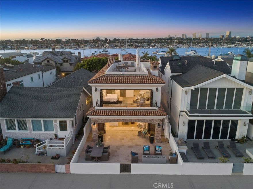 Provenance and perfection combine in this newer construction, custom oceanfront residence that displays both a European flair and a relaxed Southern California coastal-chic appeal. From the hand-crafted wall of steel and glass doors that open to a gracious covered loggia and beach front terrace, to the antique limestone floors that flow seamlessly from interior to exterior, this seaside home exhibits artistry at every turn. Splendid living and dining spaces adjoin an open format, professional-grade kitchen, highlighted by honed stone counter surfaces, wire-brushed wood cabinetry, a separate prep-sink area, and generous walk-in pantry. A dry bar with dual beverage refrigeration and abundant storage enable flawless entertaining. Ascending the stairs a thoughtful consideration of space allows for three generous bedroom suites. The exquisite master suite environ displays panoramic views from the Wedge to Catalina and beyond. Here reclaimed French Oak hardwood floors and an exquisite antique limestone fireplace set a tone of serenity. The spa bath is appointed with European fixtures, soaking tub, steam shower and walk-in dressing area. The third level roof top terrace spans the length of the residence and basks in 360 degree views up-and-down the coastline, the bay front, sparkling city lights, and mountains beyond. Exceptional materials and craftsmanship - masterfully choreographed with a relaxed seaside aesthetic - are the hallmarks of this timeless Peninsula oceanfront home.