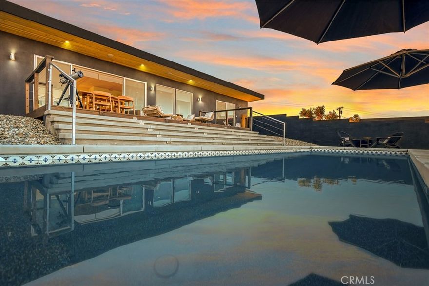 Welcome to Casa Conejo, your own private Shangrila. This stunning Joshua Tree property is over 2 acres with a fenced saltwater pool, spa, outdoor shower, and infrared sauna. As a newer construction, you will enjoy the best modern and stylish living with quality finishes, fixtures, and maxamilist decor on show around every turn. The residence consists of a primary residence with 1,412  sqft plus a separate 488 sqft casita ready to accommodate visitors and guests who come to share in this serene lifestyle. From the moment you step inside the primary residence, you will feel bright and inviting, and the open-concept design will encourage you to kick back and relax. A clean-burning, efficient pellet stove fireplace in the living and dining area ensures a warm ambiance on cool winter nights. While the kitchen is beautifully finished and ready for you to cook up a storm. Here, the eager chef is treated to a suite of quality appliances, sweeping countertops, and a large center island with breakfast bar seating. Depending on the mood and occasion, you can prepare a gourmet feast, dine indoors, or step out to the observation deck and host friends under the stars. Picture-perfect views over the landscape will provide the ideal backdrop to this stunning abode, whether you’re sipping a refreshing afternoon drink floating in the custom pool or admiring the glorious vistas of the surrounding boulders and mountains beyond. There are two master bedrooms dressed to the nines, both offering a walk-in closet and a master bath and a split-bedroom design promising peace and privacy. Completing the floor plan is a mechanical room, a compact laundry, and a detached two-car garage with electricity, mini-split heating and cooling, and windows for secure vehicle parking; it is currently a creative workspace. The separate casita has a studio-style bedroom, mini-kitchen, walk-in closet, and bathroom, ensuring added functionality for guests. This unique and sought-after property is located just minutes from the Joshua Tree National Park, with trails and hiking at your fingertips for those who like to immerse themselves in nature. There is even a rock labyrinth for meditation on the property. Easy access to schools, shopping, and major roads promises convenience, while the bustling heart of Joshua Tree is also nearby with everything you could ever need.