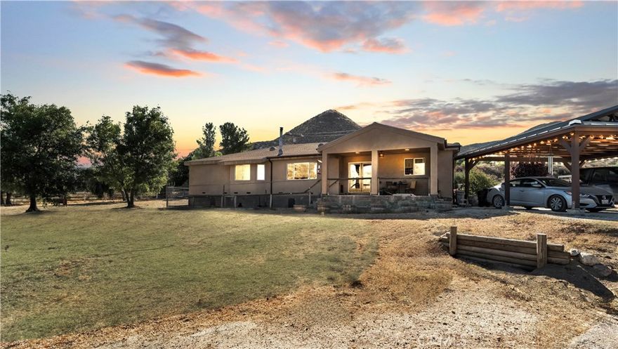 Nestled in the serene and picturesque landscape of Acton, this custom-built home from 2015 offers unparalleled privacy and breathtaking views across its expansive 11.51 acres. Designed with modern fire safety in mind, the property is equipped with an interior fire sprinkler system and a fire hydrant on the premises, ensuring peace of mind. Additionally, two 7,500-gallon water tanks provide ample water supply for emergencies. The dual glazed tempered windows further enhance the home's safety features.

This 2,238 sq. ft. residence boasts rustic elegance with Douglas fir post and beam accents. The spacious living room features a stack stone wood-burning fireplace with a hearth, perfect for cozy evenings. The kitchen is a chef's dream, complete with custom concrete countertops, under-cabinet lighting, custom cabinets with pull-outs, and a pantry with a charming barn door.

The primary bedroom is a sanctuary with French white oak flooring and a private bath featuring a garden tub and a stall shower with tiled accents. Additional amenities include a private dining room, a laundry room with ample storage, and an attached 2-car garage with a work area.

The property is a haven for nature lovers, with mature olive trees, a covered patio, a hay barn, a tack room, a pump house, and a horse turnout with an electric solar fence. A seasonal creek adds to the natural beauty of the surroundings. Modern conveniences such as a tankless hot water heater, a house recirculating pump, and a water filtration system ensure comfort and efficiency.

This home is not just a residence; it's a lifestyle. Experience the perfect blend of safety, luxury, and nature in this exceptional Acton property.