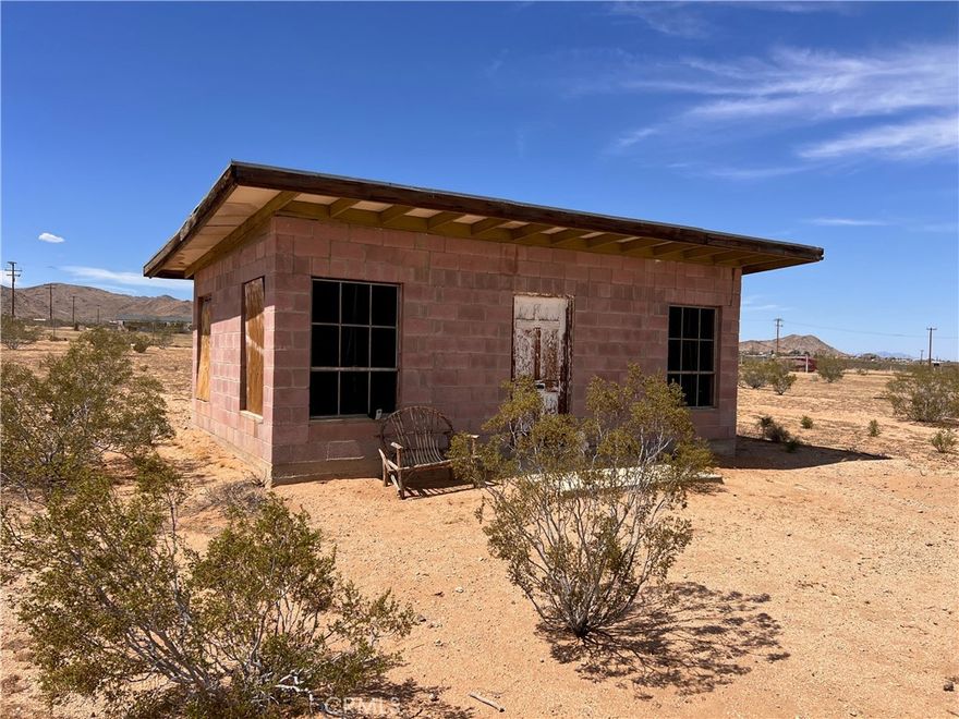 A CLASSIC PINK BLOCK CABIN ON 5 ACRES READY TO CONVERT TO A SFR! This little pink block cutie is a connection to our historic homesteading past here in Landers (and all over the Morongo basin and beyond!). The sellers have already obtained the permit to convert it to a Single Family Residence (SFR) as well as plans, been approved for a water meter and obtained a perc test. It has been sited on the property perfectly to take in the grand view of Goat Mountain and the mountains beyond. After passing through the gate, you are presented with a nice, flat buildable lot with a nice joshua tree beyond the cabin. You can fix up this little gem and use it as an off-grid weekend retreat or build a home on the flat open lot and keep the cabin as an ADU. Power poles are on two corners of the property. Bighorn-Desert View Water District says a water meter can be added to this property. (Buyer to verify water and power availability). Fully fenced. The dirt road leading to the property are easily accessible with a 2wd car. The Integratron, Giant Rock, La Copine, the Johnson Valley OHV area are all nearby. Pappy & Harriets, the Joshua Tree village and National Park are all a short, pleasant drive away.