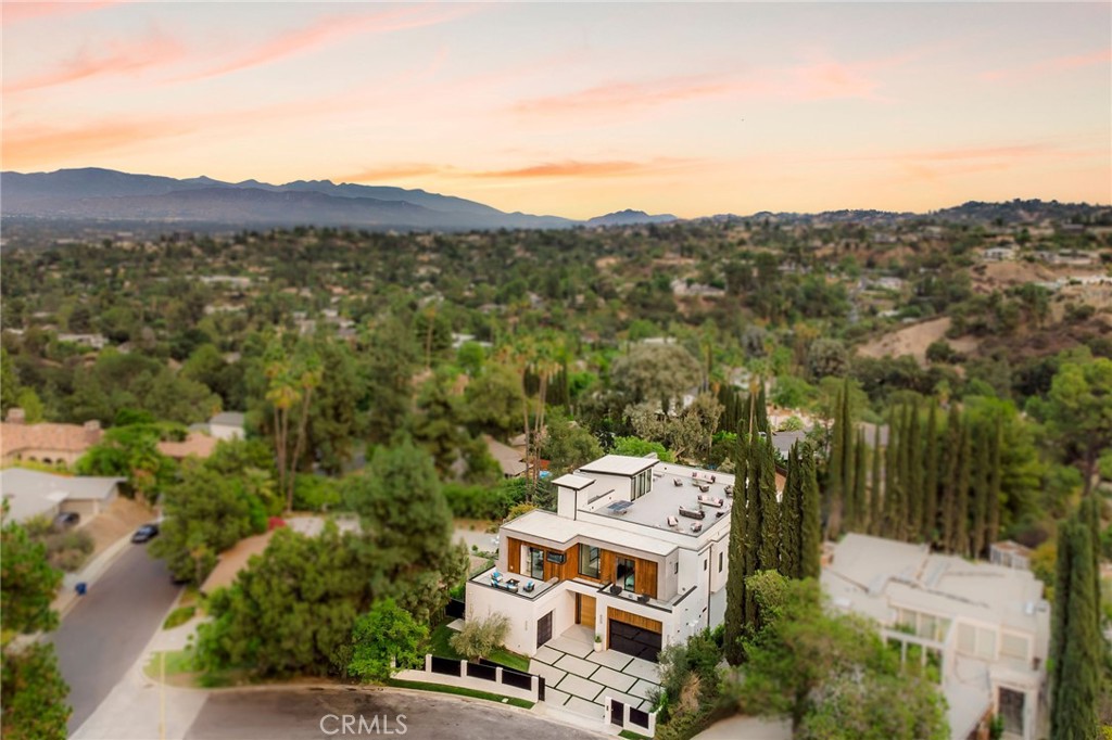 Welcome to your captivating new construction modern masterpiece with incredible views, located South of the Blvd in Encino. Located on a Cul-de-Sac, behind large private gates, sits this grand estate perched above boasting approx. 7,602 sqft of refined luxury. Awe inspiring main level welcomes you to quintessential indoor outdoor California living. Incredibly open floor plan generates a smooth flow from the sweeping two story foyer, dining room to with glass enclosed wine display, family room with stone fireplace, chef’s kitchen with double island, dirty kitchen with butler's pantry, bedroom with en-suite bathroom, and patio overlooking the ultimate entertainer's dream backyard. Upstairs beholds 4 exquisitely designed en-suite bedrooms perfect for family and friends. The romantic master retreat features a stunning fireplace, expansive walk-in closet, large flex space, luxurious spa-like bathroom, and glass sliding doors leading out to the extensive balcony with incredible views. Upstairs presents a large rooftop deck perfect for entertaining and an abundance of space to lounge and take in the scenic views. The entertainers backyard showcases a covered patio deck with outdoor fireplace, kitchen, sunken fire pit, and large pool and spa with infinity edge. Additional conveniences include Control4 smart home automation system and high tech security. Architecturally designed with meticulous perfection, this trophy estate is unlike any other. Close to the best shops, fine dining and many more.