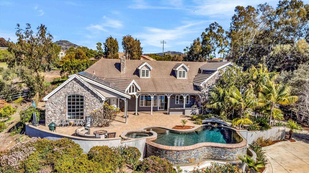 Exceptional family legacy estate located in the quiet, secure enclave of Dove Hollow and situated in the luxuriant Colony Olivenhain. The 4,628 sqft main house and fully permitted, classy 1,185 sqft Carriage House/ADU are on fully fenced and gated 2.5 acres. The 5 beds/4 baths in the house are perfect for a family, plus it lives like a single story with the Primary suite on the main level. The great room, kitchen, outdoor space and infinity pool all combine for an entertainment paradise. Abundant southwest and westerly views liven up this property and offer gorgeous SoCal sunsets. High tech galore >>> It's the only fiber optic served property in all of Dove Hollow, providing super charged high speed internet. Fiber cable from the pole is dropped into 100 Gig CAT6/8 fiber cable and trenched throughout the property. Wifi dongles and numerous security cameras are strategically placed around the property. Two separate and paid solar power systems cover all electrical costs, currently with year end credits. the ADU system includes 2 Tesla batteries. The ADU, built in 2022, is all electric with high end finishes & appliances and with beautiful westerly views. The 3-car bay below, combined with the separate 2-car garage (with lift), will appeal to any car collector. For the BBQ/smoker pro, the ADU boasts a 53" BBQ, 43" flat iron grill, 96" Santa Maria smoker/bbq and a separate pizza oven. All will love the 110" outdoor movie theater area, with subwoofer & speakers. Location is minutes away from the beach and near to all Encinitas top restaurants and shopping.