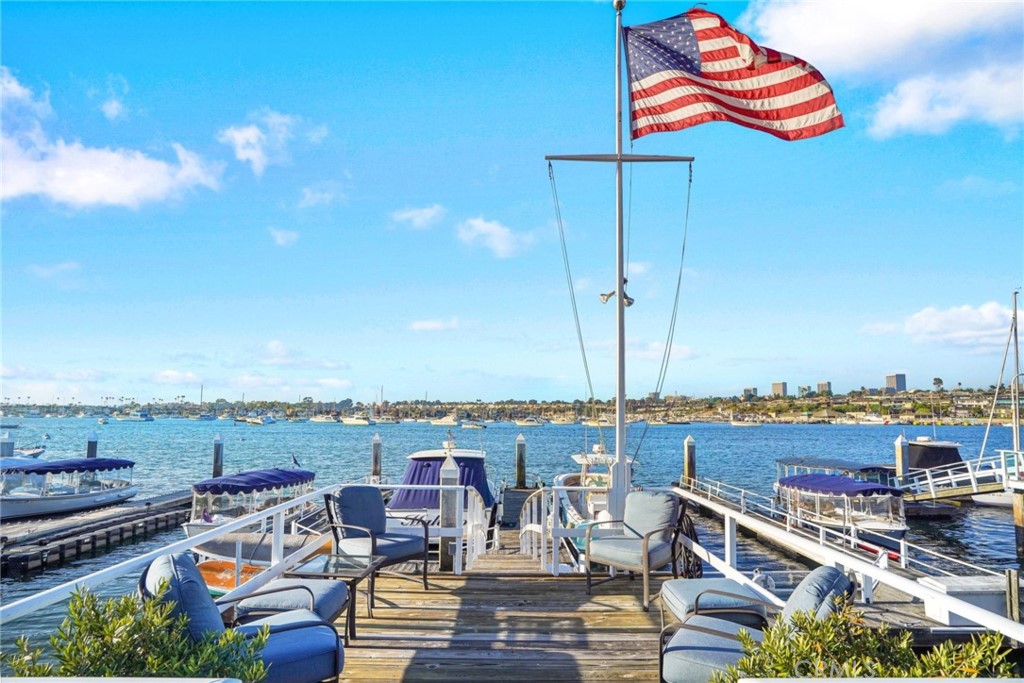 The exclusive enclave of E Bay is perhaps the most coveted collection of bayfronts on the Balboa Peninsula Point. This private location tucked behind Balboa Blvd provides breathtaking views of the Newport Harbor marina and channel. A complete remodel transformed this house into a jaw-dropping stunner, blending eastern seaboard charm with coastal chic glam! Beautifully crafted with extensive custom mill work and wide-plank oak floors throughout, this home exudes a welcoming and comfortable sophistication. Perfect for entertaining, the open kitchen is clad with premium appliances, including a Wolf double-oven range and Sub-Zero. Imagine preparing dinner while gazing at the afternoon sailing regattas and cruising yachts. Step down to the luxurious living room with gorgeous coffered ceilings and a floor-to-ceiling marble fireplace, all overlooking the glistening water, or retreat to the sanctuary of your private family/game-room, replete with a wet-bar and wine refrigerator. The master suite will provide you with an elevated perspective of the tranquil bay (and life) as you enjoy a cup of coffee on your private balcony or read your favorite novel in your lush sitting area as the fireplace glows. A spa inspired bath provides a soaking tub, oversized shower and dual vanities. A large second ensuite master and 2 additional ensuite bedrooms occupy the second floor, along with a small office area and laundry room. Indulge in the sun on your spacious patio and keep warm in the evenings with the outdoor fireplace. The expansive yard cascades into 3 terraces, including a brick deck, a large grassy area for the kids to play and a landing that sits above the water, lending enough space for hosting a 100+ guest events. The dock can hold a 40+ vessel and side-tie for your personal Duffy YEAR ROUND. The home sits on a 35 ft. wide lot with a 3 car garage. The Peninsula Point is famous for its iconic festivities, including the Christmas Boat Parade, 4th of July parade and fireworks, Friday night potlucks at the private Bay Beach, the private tennis club, and all just steps to the world renowned beach "THE WEDGE" where you can enjoy a surfing spectacle when the south swells arrive. Don't miss your chance to make this slice of paradise your home.