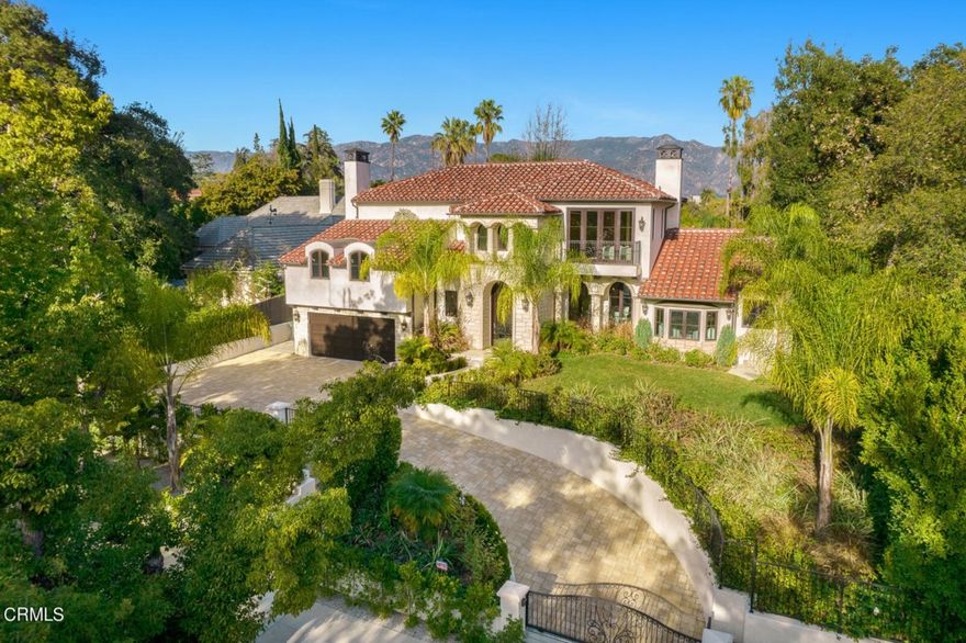 Located in the premier Oak Knoll neighborhood, a short stroll to the Langham Hotel and perched above the street, this gated modern Mediterranean home with pool and cabana offers the highest quality in custom finishes, details, and construction as well as impressive views of the San Gabriel mountains. Completed in 2019, the majority of the main residence as well as the entire cabana were built from the ground up with the remaining  completely remodeled. An imposing custom wrought-iron front door invites you into the main floor living area and expansive gourmet kitchen featuring Viking and Bosch appliances and two islands. In addition there are two ensuite bedrooms downstairs (including a downstairs primary) and three ensuite bedrooms upstairs accessed by a dramatic wrought iron staircase featuring a gold-colored dome ceiling. The upstairs primary suite features hand-hewn truss beams, a stone wall with Montigo fireplace, a dramatic bath featuring a wall of Oceanside glass tile, a stand-alone soaking tub and an oversized dual-headed shower and custom walk-in closet. Perfect for entertaining, three sets of French doors open onto an expansive Versailles-pattern stone patio with salt-water pool, column-lined covered dining area, built-in barbecue and glass fire pit. The versatile cabana offers an open floor plan with hand-hewn truss beams, a kitchenette, bathroom with shower, and its own split-air unit. This exquisitely-finished custom home in a prime Pasadena location provides a refreshing modern take on Mediterranean architecture.