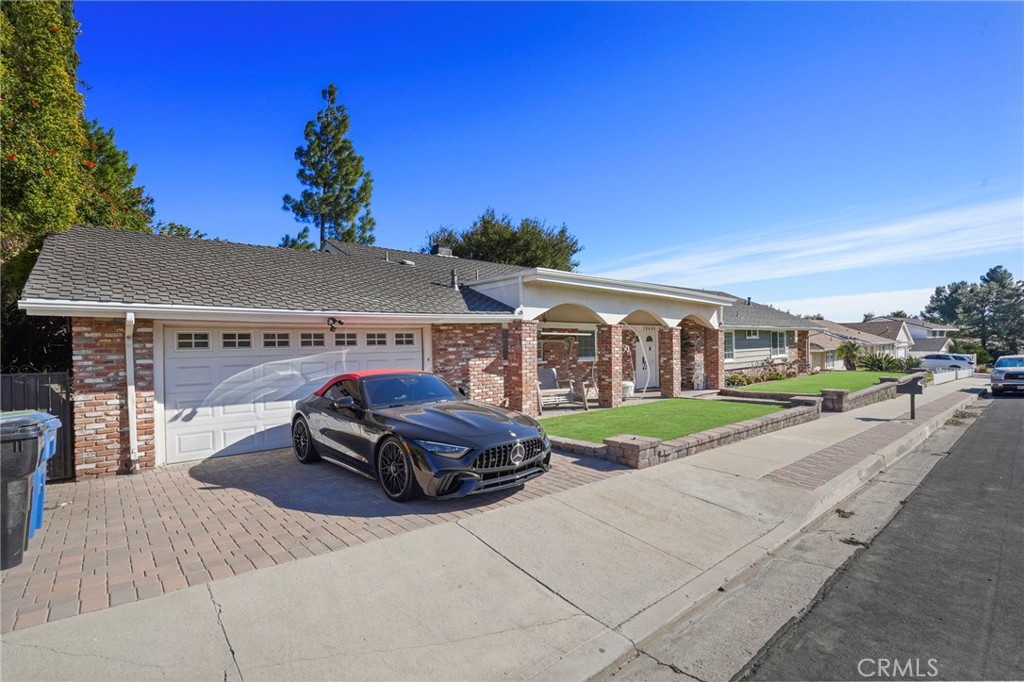 This stunning single-story home in the heart of Granada Hills boasts incredible curb appeal and a welcoming ambiance. With 4 bedrooms and 3 bathrooms, this property offers ample space for comfortable living. The large and airy living room flows seamlessly into a cozy family room, both featuring a dual-sided fireplace and breathtaking views of the lush green backyard. The dining room is conveniently located adjacent to the modern kitchen, which is equipped with sleek quartz countertops and stainless steel appliances. The primary bedroom features its own private ensuite bath, while two additional bedrooms share a well-appointed bathroom. The fourth bedroom has easy access to a nearby hallway bathroom. The spacious backyard, overlooking a scenic golf course, is perfect for relaxing or entertaining. Adding to the home's convenience, an attached two-car garage provides direct access, along with an in-garage laundry area for everyday ease.