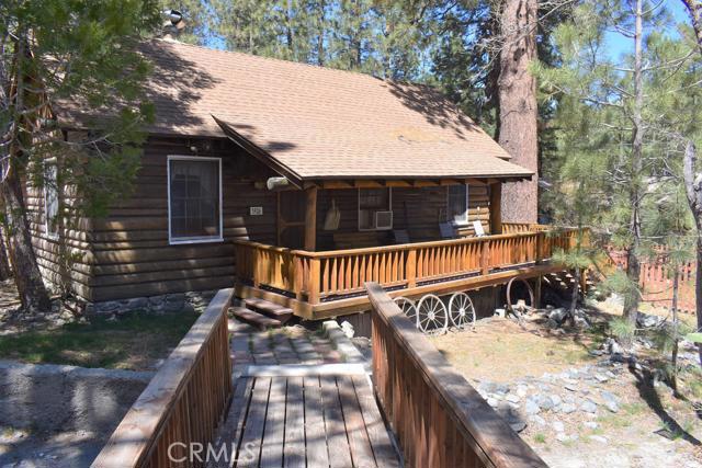 Historical fully furnished cabin just a few blocks to the village! Come check out this nearly 1000 square foot, 2 bed 1 bath plus loft bedroom blast from the past on a large 10,000 square foot corner lot. You will absolutely love relaxing on your covered porch with native log beams any time of year, and around the corner sprawl out on the deck off the kitchen, perfect for that Memorial Day BBQ! The entry is quite amazing, as it feels like you've stepped into a time capsule of Wrightwood history. A large native rock fireplace is the centerpiece of the home, but the elegant chandelier hanging from your vaulted open native log beam ceilings is a close second. Original hardwood floors through the living room are waiting for a quick refresh to bring out their true beauty. This great room doesn't disappoint. From there we can head to our modest but efficient kitchen and antique gas stove, or to the two large beds downstairs with a 3/4 bath situated perfectly between the two bedrooms in the hall. Convenient indoor laundry with a newer stackable unit is right off the hall as well. Up the stairs to the loft bed, with enough room for the grand kids and one of a kind original stained glass window, with other original stained glass throughout the house to hunt for! Now lets talk land...10,000 square foot, fully fenced corner lot with so much more room to expand, room for a RV (or two!) and just a few blocks from the village, Country Club and all Wrightwood has to offer! Association Amenities: None # of RV Spaces: 0 Special Features: BC,CC,LF,OBNONE Lot Location Type: Standard Location Landscaping: Natural # of Attached Spaces: 0 # of Detached Spaces: 0