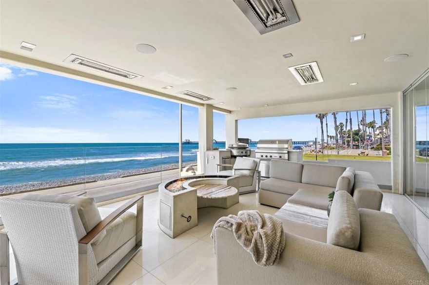 Located just one block from the heart of the newly developed, vacation destination of downtown Oceanside.  This bright and spacious oceanfront home presents exquisite panoramic whitewater views.  As the property neighbors Tyson St Park, the historic Oceanside Pier is in full display from both the western and northern facing windows.  Catch the breathtaking sunset with family and friends from the expansive covered patio, featuring two gas firepits and an outdoor kitchen.  The frameless folding glass wall truly welcomes the outside, in.  With a complete remodel of the main floor in 2018, this is an entertainers dream.  The gourmet kitchen features rare St Laurent marble countertops, a tempered glass island, Wolf range and double oven, as well as SubZero refrigerator and wine fridge.  Custom built in, walnut cabinetry in the living room and media room adds an element of warmth to the open floorplan.  Backlit onyx surrounds the fireplace and bar.  Equipped with smart home technology, control lighting and entertainment with ease by the use of Savant media, Sonos sound and Lutron lighting.   The second floor master suite opens to sweeping ocean views through its floor to ceiling windows and personal patio.  With an additional 3 bedrooms, each with its own bathroom, there is plenty of space for guests.  Never worry about guest parking with the 5 car subterranean garage and 4 space driveway.  Access all levels of the home by elevator.  Take a stroll on the beach, walk the wooden pier, dine at the downtown establishments, soak up the sun, relax to the sound of the crashing waves.  This property offers an experience that you will want to share with loved ones.