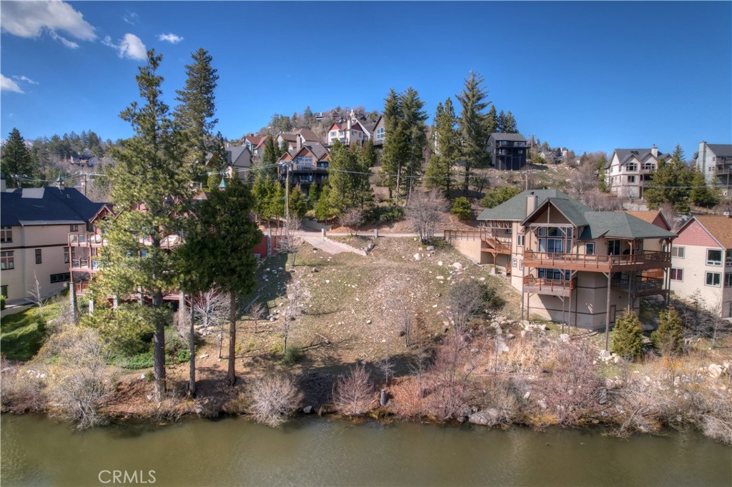 The Final Moment to Own a Vacant Buildable Luxury Lake Front Lot! Preliminary Plans for a stunning home are included in the sale! Breathtaking lake views in a tranquil setting are the perfect blend for a mountain master piece. The seller has woven a vision of natural beauty and luxury to create your dream home transformation. While taking in the stunning surroundings, notice the neighboring, prestigious, Multi-Million Dollar Mansions locally known as "Celebrity Row". This is a golden lifetime opportunity to awaken to fragrant summer breezes and whispering pines then taking the boat for a spin, or teeing it up on the golf course. The 3/4 inch Water Meter and Sewer Meter are both Preserved, saving the future owner nearly $50K in fees and saving time during building process. A small one time payment of $3750 buys a new fire sprinkler meter (LACSD: lakearrowheadcsd.com). This Lot also includes eligibility to Lake Arrowhead membership (ala-ca.org), creating endless opportunities for fresh water swimming, boating, skiing, wake boarding and trail hiking. Other nearby activities include The Lake Arrowhead Village, nearby dining and shops, Sky Park at Santa's Village, Snow Valley, Snow Summit, Bear Mountain and Snow Drift Snow Tubing Park. Transform your dreams and embark on this journey... creating your vision imbued with magical mountain serenity (Arrowhead Woods Architectural Committee awac.biz).