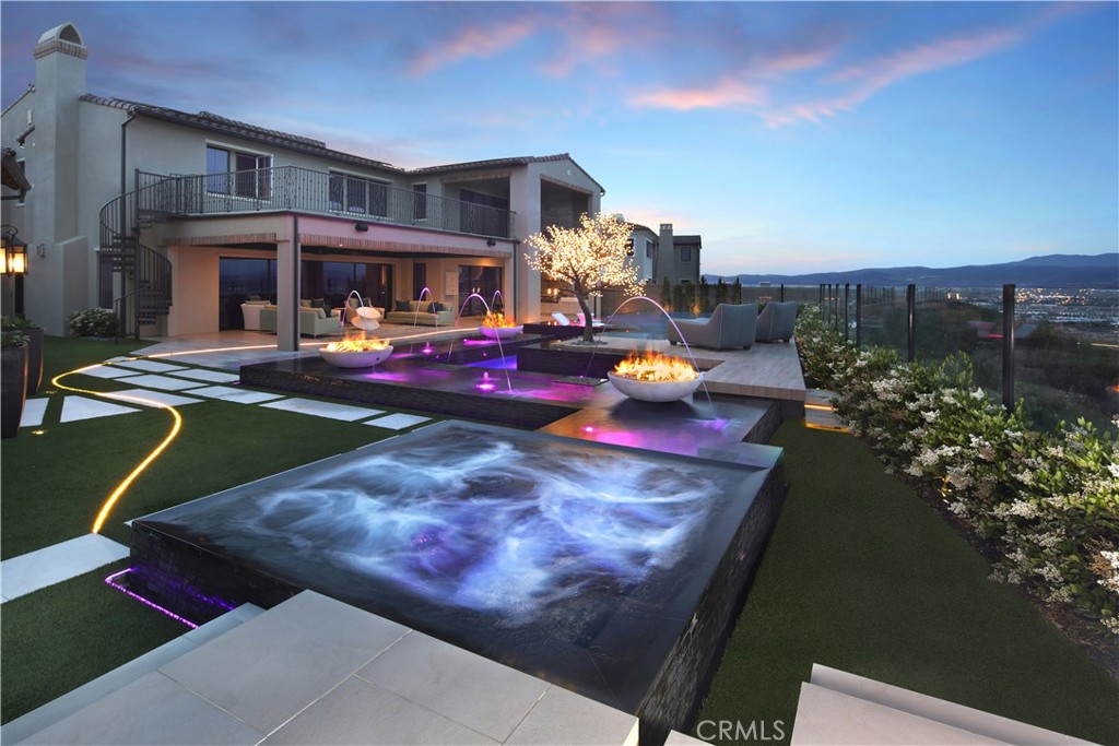 One of THE most impressive contemporary homes and PREMIUM VIEWS in all of Irvine. Situated on an expansive 13,000+ SF cul-de-sac LOT directly adjacent to the recently notable $9 MILLION 138 Scenic Crest. Discover the stunning 136 Scenic Crest - with breath-taking panoramic city lights and mountain views, unmatched upgrades, and a spectacular backyard with infinity pool and space recently for a wedding with over 100 seated guests. Upon entry into the approx. 5000 SF residence, one is met with a beautiful wide staircase and 2-story foyer centered with a magnificent chandelier. The gorgeous custom flooring and striking designer finishes throughout are enhanced with natural light in this popular “Cassis” Marbella open floor plan. Beyond the Main Floor en-suite bedroom and office with a private courtyard, one is drawn into the spacious family room and entertainer's Dream Kitchen boasting dual islands, custom Caesarstone countertops, designer backsplash, floating cabinetry and shelves, 60-inch SUB-ZERO refrigerator, WOLF ovens and stove, adjoined to a prep kitchen and dining area. Through sets of oversize pocket doors you'll experience seamless indoor/outdoor luxury living and be mesmerized by the one-of-a-kind modern backyard w/ infinity pool and decks designed with fire pits and bowls. The outdoor California logia includes a large retractable movie screen for outdoor movies to be viewed from inside or the pool. The backyard also includes a wrap-around side yard, Zen-like fire and water wall, as well as a separate Casita with living room, kitchenette, bedroom, bath, and pocket doors. The upstairs reveals 3 additional spacious en-suite bedrooms and Primary Suite, as well as a loft and balcony for sunsets. The expansive Primary Suite, with custom bath and closets, includes an oversize 575 SF deck, with private spiral staircase to the yard, for another level of panoramic views! Other features: 2 garages w/ storage and EV, fully-paid solar panels, water treatment, and more! In prestigious 24/7 guard-gated Hidden Canyon - voted as the #1 planned community in the U.S. a few years ago and one of OC’s most sought-after contemporary home communities. Nestled in the coastal Laguna Canyon Hills, and one of the most ideally located suburban neighborhoods in all SoCal - with quick access to the 405, 5, 133 Freeways and 73 and 241 Toll Roads, airport, world-class shopping, dining, and only 7 miles to Laguna Beach. In University High School district. Welcome to luxury living!