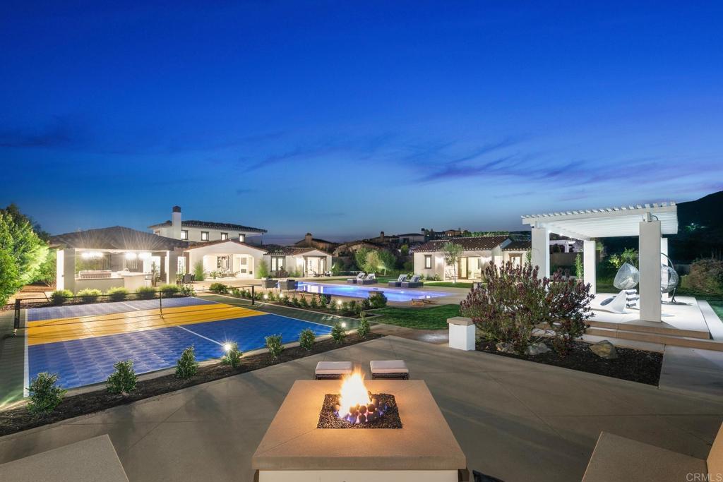 Nestled in the prestigious gated community of Del Sur Estate in Coastal North County San Diego, this sprawling 6,300+ square foot luxury estate is a masterpiece of modern elegance and design. Set on an expansive 34,000+ square foot lot, the property boasts seven (7) ensuite bedrooms, including a detached junior casita at the entry courtyard and a full ADU guest house nestled among the back yard oasis, perfect for extended family or guests seeking privacy. As you step inside, you're greeted by an abundance of natural light that highlights the exquisite finishes throughout. The main living areas are designed for both comfort and sophistication, seamlessly blending indoor and outdoor living. High ceilings, large windows, and an open floor plan create a spacious ambiance that is perfect for entertaining or simply enjoying the tranquility of this luxurious retreat. The gourmet kitchen is a chef's dream, featuring top-of-the-line appliances, custom cabinetry, and an expansive island that serves as the heart of the home. Adjacent to the kitchen, the living and dining areas open up to the beautifully landscaped outdoor spaces, where you’ll find a resort-style pool, multiple lounge areas, and a fire pit, all designed to take full advantage of the breathtaking views that stretch across the horizon. The primary suite is a sanctuary of relaxation, offering direct access to the outdoor amenities and featuring a spa-like bathroom with a soaking tub, twin shower, dual vanities, and an expansive walk-in closet. Each additional bedroom is a private oasis, complete with its own ensuite bathroom and high-end finishes. Outside, the property offers endless opportunities for recreation and relaxation. The large pool and spa are perfect for cooling off on warm San Diego days, while the outdoor kitchen and dining areas make alfresco entertaining a breeze. The estate’s thoughtful design extends to every corner, including a pickle ball sports court, expansive lawns, raised bed veggie garden, and beautifully manicured grounds. This extraordinary estate is not just a home; it's a lifestyle. With its unparalleled amenities, prime location, and luxurious details, it offers the ultimate in Southern California living. Don’t miss the opportunity to make this dream estate your reality.
