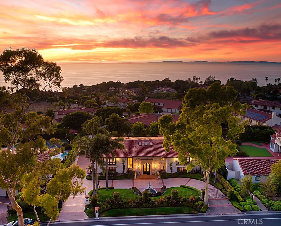 Welcome to this stunning custom-built Montecito-style estate located in the prestigious Palos Verdes Estates. This gated property features a horseshoe driveway and water fountain that set the tone for the luxurious and serene lifestyle you will experience within. Upon entry, you are greeted by an impressive foyer boasting high ceilings, an intricately designed iron staircase, and imported Moroccan tiles.
The main floor features a spacious open floor plan with beautifully appointed high-end designer finishes and ample natural light. A formal living room and true entertainer’s bar provide the perfect setting for elegant entertaining and casual gatherings alike. The bar includes 2 Marvel wine refrigerators, a Marvel ice maker and a Fisher and Paykel dishwasher. The expansive family room is equipped with a cozy fireplace and the dining room is conveniently located adjacent to it and the kitchen.
The kitchen is a chef's dream, with top-of-the-line appliances, custom cabinetry, and a spacious center island. The appliances include Wolf gas range with 6 burners, a ceramic griddle and two gas ovens, two additional Wolf electric ovens and a steam oven, full sized Sub Zero refrigerator freezer and separate beverage fridge, a farm sink and vegetable sink, and two cove dishwashers.
Also on the first level, the oversized game room has custom motorized drapery and opens to the yard. Beyond, closed off by pocket doors, is the office with windows to the front of the property.
Upstairs features a total of 5 bedrooms, each with a full ensuite bathroom providing ample space for family and guests along with a laundry room. The primary suite is a true retreat with a fireplace, sitting area, walk-in closets, balcony, and a luxurious spa-like bathroom with custom vanities, a soaking tub, and a separate shower.
The backyard is a serene and private paradise, featuring a pool and spa and mature landscaping, a beautiful stone fountain, and ample seating areas to enjoy complete relaxation and sunshine.
This exceptional estate underwent a complete renovation in 2019, with no expense spared. The renovation included custom lighting and flooring throughout, new cabinetry, doors, closets, security cameras, a stone facade, complete electrical rewiring and conversion to a smart home as well as upgraded finishes and appliances. The total cost of the renovation was $2.5 million, ensuring that this home is move-in ready and truly one-of-a-kind.