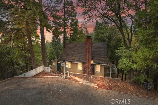 Smell the towering pines and enjoy everything this charming cabin in the mountain has to offer. Delivered fully furnished, this well maintained, two bed, one bath home is ready for you to start making memories. Grab a book and cozy up by the wood burning fireplace in the wood paneled living room, enjoying the sunlight from the picture windows. Unfinished basement provides loads of storage, laundry hookups and a workbench. Large lot with plenty of trees to hang a hammock, a brick entertaining pad for BBQs, gentle slopes for sledding, and the babble of a seasonal brook all add to its magic. All that with Level entry and plenty of parking. Conveniently located on a plowed/maintained road, just 5 minutes away from Lake Gregory or Highway 18 for easy commuting. At this price, it's going to go fast!