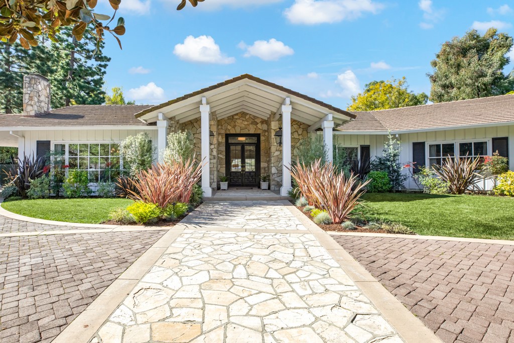 Discover your own private 3.3-acre estate in the exclusive gated city of Rolling Hills. Designed by the legendary architect Paul R Williams, the home showcases elegance and natural light throughout 5,730 total square feet of living space. A long private driveway welcomes you as you drive along the tennis court to a circular motor court on this exquisite property. This gorgeous home features 5 total bedrooms (1 bedroom currently being used as a gym), 5 full bathrooms, 3 half baths plus an office / library filled with custom built-ins along with a 3-car garage and additional guest parking. In addition to the main residence, there is a beautiful guest house offering one bedroom with a full bath and half bath. The 978 sq foot guest house also features a full bar, a living room with pool table, seating area and a floor to ceiling stone fireplace along with French doors opening up to the pool & spa.
As you enter the main house, a large formal living room greets you with high beamed ceilings. Large panoramic windows offer beautiful views of the pool and vineyard. Two sets of French doors off the formal living room lead to the lushly landscaped yard with a newly resurfaced saltwater pool and spa and covered patio for outdoor entertaining. A large separate family room with views of the pool offers a wood burning fireplace and bodes a wall of custom-built ins. The dramatic formal dining room has large windows with views of the tennis court, a floor to ceiling fireplace and beautiful beamed ceilings that leads to the upgraded kitchen with high-end stainless-steel appliances. Elegant master suite has a spa-like master bathroom, large walk-in closet and a private patio overlooking this incredible estate and massive yard. City views complete this incredible yard. The property proudly features a large vineyard with approximately 180 vines growing three different types of grapes to make Pinot Grigio, Pinot Noir, and Cabernet wine in the fall of 2022. There is also a large horse barn and paddock located near the private tennis court.
This property is a must-see and a rare opportunity to own a generational type of estate on a flat and usable lot. Located in the sought after 24-hour guard gated community of Rolling Hills within the nationally ranked Palos Verdes School District.
Property Video https://player.vimeo.com/video/684774662