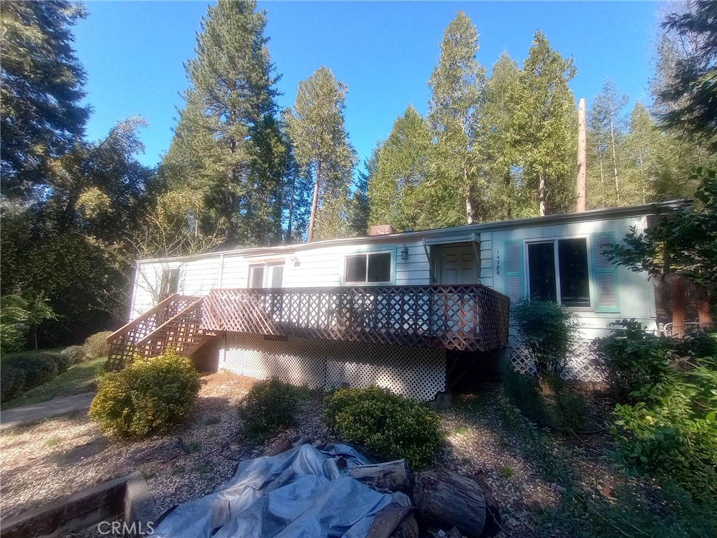 Discover the charm of mountain living in this 2-bedroom 2-bath home. This home features vaulted ceilings, a wood-burning stove, an oversized laundry room, and a built-in hutch for storage. The kitchen features a well-designed layout that opens to the main areas of the house. Unwind in the master suite, which includes a shower-in-tub design and plenty of storage space. Outside there is a beautiful wooden deck and a fully fenced-in yard. On this great sized lot, there are raised garden beds, waterspouts throughout the property, great pathways, and easy to maintain landscaping. There is a storage shed out back and an outbuilding in the front when you enter the driveway, the possibilities for use of that building are endless. This home is being sold as is and with a little TLC this will be the perfect place to call home! This property has the potential to shine bright. Take advantage of the affordable price and make this house a home that you’ll be proud of. With the cozy wood-burning stove, spacious backyard, and plenty of natural light, you’ll never want to leave.