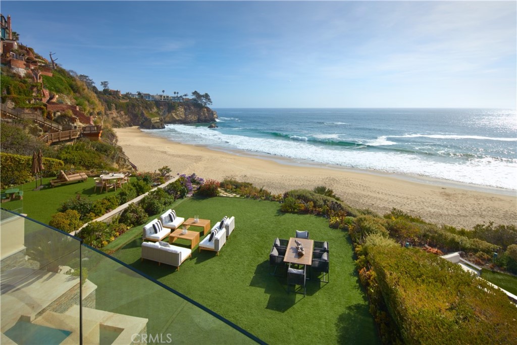 Composed without compromise, this paramount piece of architecture behind the guarded gates of lower Three Arch Bay allows you to live each day in a luxurious beachfront escape. Newly refreshed interiors of approximately 6,419 square feet are concealed by bespoke facade of custom-cut ledger gemstone, Gascoigne limestone, and copper roofing. Rivaled only by the riveting views, thoughtfully chosen finishes such as imported limestone flooring, leather upholstered walls, Portoro and Emperador marbles, and Honduran Mahogany doors work in tandem to create living spaces that are both intriguing and tranquil. Among the home's resort-style amenities are an executive office, walk-in vault, director’s quality theater, billiards room serviced by a wet bar, 2,200-gallon saltwater aquarium, and indoor spa. Take in the ocean breezes from multiple grand ocean-front terraces and lawn which hosts sparkling pool above a sequestered beach with powdered sand and turquoise seas. Connecting all four floors is a commercial elevator as well as a dramatic Brazilian Cherry stairs with glass and stainless rails. Sited to capitalize on the panoramic ocean vistas, the immaculate primary quarters features a private terrace, walk-in closet, and stunning spa-like bath appointed by a soaking tub, oversized walk-in shower, and dual sinks. Residents of Three Arch Bay enjoy a community park, clubhouse, tennis court, and basketball court. Encompassing all the hallmarks of a five-star residence, 25 Bay Dr presents luxury at your fingertips, unmatched beauty at your windows, and the ocean at your feet.