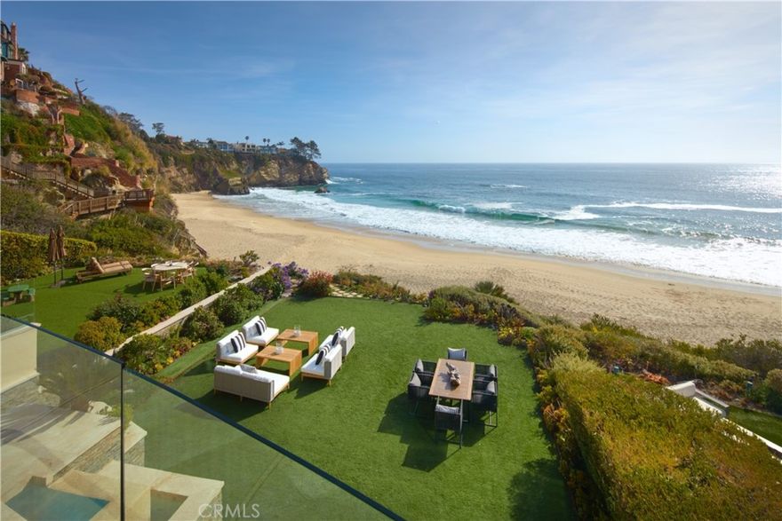 Composed without compromise, this paramount piece of architecture behind the guarded gates of lower Three Arch Bay allows you to live each day in a luxurious beachfront escape. Newly refreshed interiors of approximately 6,419 square feet are concealed by bespoke facade of custom-cut ledger gemstone, Gascoigne limestone, and copper roofing. Rivaled only by the riveting views, thoughtfully chosen finishes such as imported limestone flooring, leather upholstered walls, Portoro and Emperador marbles, and Honduran Mahogany doors work in tandem to create living spaces that are both intriguing and tranquil. Among the home's resort-style amenities are an executive office, walk-in vault, director’s quality theater, billiards room serviced by a wet bar, 2,200-gallon saltwater aquarium, and indoor spa. Take in the ocean breezes from multiple grand ocean-front terraces and lawn which hosts sparkling pool above a sequestered beach with powdered sand and turquoise seas. Connecting all four floors is a commercial elevator as well as a dramatic Brazilian Cherry stairs with glass and stainless rails. Sited to capitalize on the panoramic ocean vistas, the immaculate primary quarters features a private terrace, walk-in closet, and stunning spa-like bath appointed by a soaking tub, oversized walk-in shower, and dual sinks. Residents of Three Arch Bay enjoy a community park, clubhouse, tennis court, and basketball court. Encompassing all the hallmarks of a five-star residence, 25 Bay Dr presents luxury at your fingertips, unmatched beauty at your windows, and the ocean at your feet.