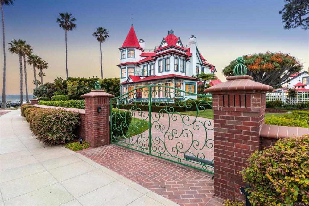 Spectacular Queen Anne Victorian affectionately known as "The Baby Del" on rare half-acre lot. A few Steps to the white sands of Coronado’s renowned beach, the “Baby Del” proudly stands as one of San Diego’s most magnificent Victorian landmarks. Its architecture is reminiscent of the Hotel del Coronado a few blocks away. Built in 1887, then known as The Livingston House, it was a news-worthy monumental move on land and barge in 1983 from San Diego to its majestic seaside location, and has been lovingly restored and enjoyed by its two owners since. Private 1/2 Acre Compound with Gardens, Turrets, stained glass, wrought-iron work, copper gutters and gold leaf create a bond to an earlier, more gracious time. The home was designated as a Historical Landmark and received a Mills Act designation, which makes it eligible for certain property-tax reductions and is truly One of a Kind. First time for sale in 26 years. At 55 feet, this Estate is the tallest house in Coronado. Additionally it is one of the eight largest home lots on the island allowing for extensive gardens, abundance of parking, an oversized garage with alley access, gated front circular driveway, and three Guest Houses, two of which are located in what was formally used as a Carriage House built in 1887. The interior of the Estate is a creative blend of classic and modern amenities with Panoramic white water Ocean Views and breezes, as well as views of the City Skyline, Point Loma, Mexico and Coronado Islands. 12+-foot-tall ceilings, arched doorways, turrets, time period leaded-glass front door and windows, three fireplaces, wine cellar in basement accessible by staircase or elevator, formal Dining Room, Parlor, sun room with tile floors and drain is perfect for pet washing room, 3 to 5 spacious bedrooms, Study, secret playroom, Chef's Kitchen. 3 additional bedrooms in Guest Houses. Solid steel spiral staircase connects the four levels on the house adjacent to elevator. Grand "Crown Room" with 19 glass doors with wraparound deck lead to the private compound and gardens designed for entertaining large and small gatherings. Glass enclosed showroom is a beautiful focal point of the grounds and is perfect for displaying antique vehicle (tractor does not convey), use for a greenhouse or hosting a bar. Gazebo, outside shower, private patios, BBQ and customized serving areas. Oversized garage set up for caterers with multiple sinks, microwaves, refrigerator, storage, and has attic above for added storage alley access. Additional storage for recreational toys through double gate on alley. Garden lighting and spotlights highlight the lush and beautiful landscaping including the exotic Victorian Dragon tree which was relocated by crane to it’s new surroundings in 1983. The dragon tree, also known as Dracaena Draco, is native to the Canary Islands and is thought to be the oldest living plant. With its name derived from the Greek expression for “female dragon,” it is known for its reddish sap, said to resemble the blood of a dragon and thought to have medicinal value. Fruit trees, Melalucea, Podocarpus, and Ficus Trees form a a privacy hedge around estate. Just a short drive over the bridge or ride on the ferry from Downtown San Diego, this special Island has been known as Hollywood’s Playground since the 1920s. Presidents, Hollywood Stars and Starlets discovered that The Hotel Del Coronado was the “in” place to stay. This lovely little Family Friendly Village has superior walkability to so many community events, concerts in the park, dining, boutiques, entertainment, golfing, sailing and beach fun. Last but not least, Coronado boasts a top Award Winning School District making this Estate an ideal home for families.