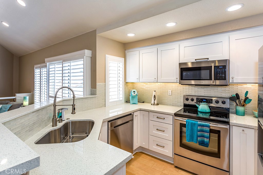 Southern California living at it's best! This sun-filled carriage unit in upper Palm Court is centrally located to nearby shopping, restaurants and a quick jaunt to our world-renowned beaches. With a beautifully remodeled kitchen, featuring quartz countertops, new stainless steel appliances, glass backsplash you will be inspired to create yummy dinners for your guests. Beautiful maple hardwood floors throughout, cozy fireplace, ceiling fan, plantation shutters, and choose from 1 of 2 balconies to enjoy a glass of wine at the end of the day. In addition, the bedroom has a spacious walk-in closet and high ceilings. The state of the art NEST HVAC thermostat eliminates the stress of getting your home comfortable prior to your arrival. Relax in the jet tub in the updated bathroom with a newer vanity, and custom light fixtures. Direct access to your private garage with the epoxy coated floor is an additional bonus! Palm Court boasts an array of community features for you to enjoy, tennis courts, 2 pools, spa, playground, and barbecue area. You'll find this community tranquil and an oasis to come home to.