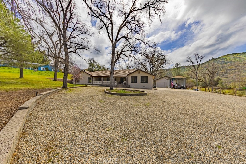Come and check out this beautiful 3 bedroom 3 bath home in a very highly desirable area! The home is located on an approximate .92 acre lot with a view of the Fresno River adjacent to the back yard, a beautiful mountain view, and lots of oak and pine trees. The back yard also has a nice above-ground spa, and an outdoor kitchen with a built-in BBQ and Refrigerator with a counter that you can enjoy while relaxing in the covered outdoor patio area. For the Shop enthusiasts, the home includes a very large enclosed shop (approximately 936 sf), which has an automatic door, enclosed cabinets, and a separate locked area. The front of the home has plenty of parking to include a circular driveway, a step-up into the covered patio area, and a covered car port which is located on the side of the home, across from the large enclosed 3-car garage, with shelving. Step inside this beautiful home, and you will find a tiled entry way that guides you into the living area (includes a gas brick fireplace), built-in shelving, and bamboo flooring that leads into the kitchen area and provides beautiful views of the backyard. The kitchen has granite counter tops, a gas stove with a connected wooden bar area, a double oven, dishwasher, a built-in wine fridge, and a portable microwave. The dining room (and adjacent extra room) has bamboo flooring (5 extra boxes are stored in the garage), and oak cabinets all along the wall for lots of storage. The large primary bedroom has a beautiful view of the backyard, and the primary bath has a nice spa tub, a tiled shower, and tiled counter tops. The 2nd bedroom has a double closet with an adjacent bathroom to include granite counter tops, and the 3rd bedroom includes nice built-in wood shelving. The large laundry room, adjacent to the kitchen, has tile flooring, formica counter tops, and provides access to the 3rd bathroom. Plenty of space to add a fourth bedroom, an additional bathroom and kitchen in detached shop for use as a short term rental. The formal living room could also be used as a bedroom.
Call for your viewing today, as this home is a "must see", and close to Yosemite National Park and Bass Lake.