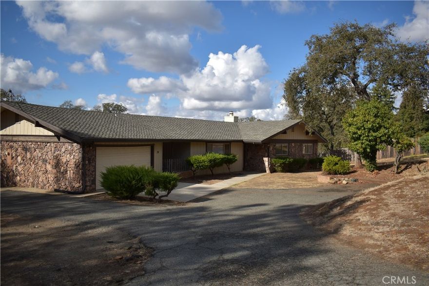 Welcome home to this gem in a highly desirable neighborhood overlooking Oroville. This home is on a dead-end road with spectacular views of the valley from the deck and a view of Table Mountain from the back yard. This 3 bedroom/3 bath home has a semi-attached garage which is separated by a breezeway. Inside the garage area, you'll find a 2-car garage with two other rooms and a bathroom. Across the breezeway is a side entrance to the house. You enter through the large laundry room with its own sink. It leads into the kitchen and dining area which has built in bookshelves, a wood burning stove, and a sliding glass door to the deck with fantastic views. Imagine yourself entertaining in this space, drinking your morning coffee or enjoying the evening sunset. The living room at the front door is large and leads to a hallway where you'll find the primary suite and two other rooms, one of which also has a sliding glass door out to a patio. Below the deck, you'll find a large covered concrete patio with expansive views as well. There is plenty of space behind the house to do as you wish. This is a one-of-a-kind home!