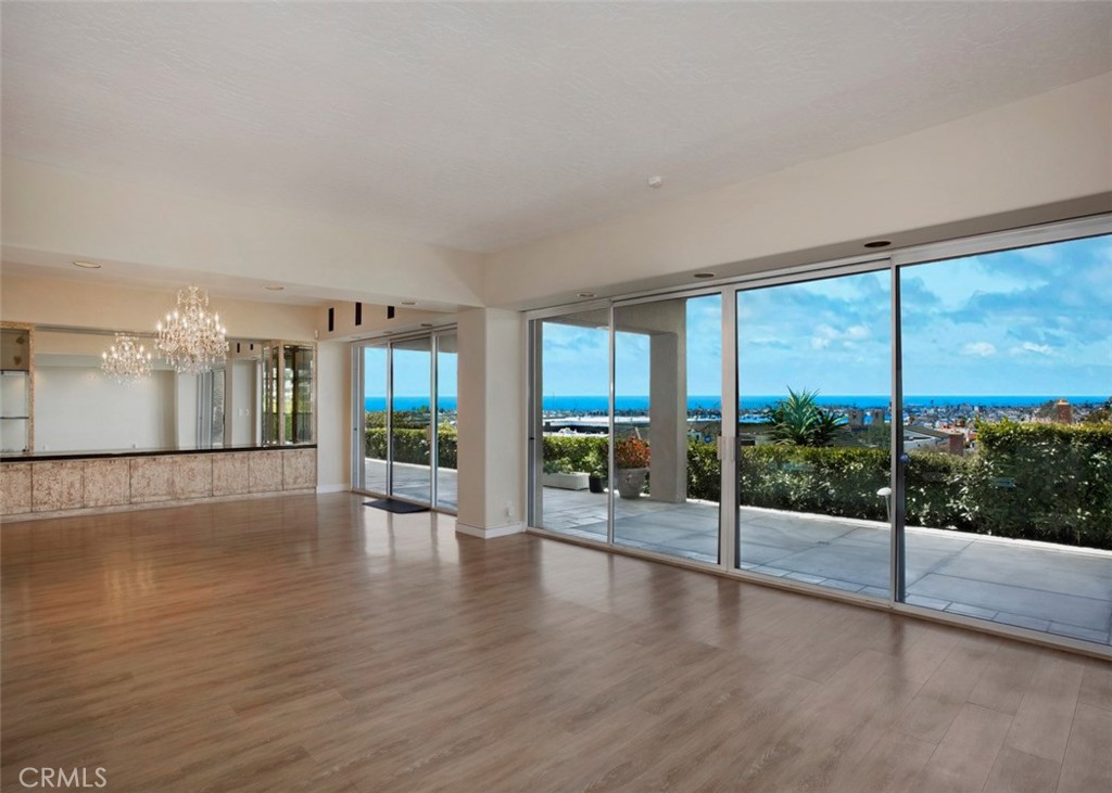 This seaside one-story treasure is situated on a prime 12,040 square foot view lot, in the heart of Corona del Mar, complete with ocean, harbor and Catalina Island views from all main rooms. Enter through a gated courtyard sanctuary patio and step into the open-concept designed home where the amazing sweeping Catalina Island, Ocean and Harbor views greet you. The spacious living room with fireplace opens to the dining room area with custom built-in cabinetry and to the sleek kitchen boasting stainless steel appliances, stone counters, center island plus bar and breakfast area...all with ocean views. A family/media room opens to the lovely courtyard and includes a fireplace, an attached bath plus kitchenette/bar. The superb floorplan includes two primary suites each with large closets, dual vanities and luxurious details plus full ocean views. Two additional secondary bedrooms include a Jack & Jill bath and both view the lovely courtyard. Currently the 4th bedroom is organized as an office with a built in desk and shelving and double door entry. Rounding out the special features, the home includes a large powder room, a large laundry room with sink and storage, and an attached 3-Car Garage. With 4163 square feet, this home includes 4 Bedrooms, 4.5 Baths, spacious living, dining and kitchen areas, a separate Family Room, massive storage, and more...the back yard patio extends the length of the house and is perfect for entertaining and capturing the dazzling Catalina Island sunset views. All main rooms open to the delightful courtyard or to the ocean view patio designed for easy indoor/outdoor beach living. Just moments to the sandy beaches and in close proximity to Fashion Island, the Newport Beach Country Club, Yacht Clubs, Balboa Island, fine dining and shops. Enjoy the best of coastal living all year around at 1815 Galatea Terrace in Corona del Mar.