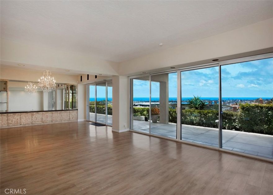 This seaside one-story treasure is situated on a prime 12,040 square foot view lot, in the heart of Corona del Mar, complete with ocean, harbor and Catalina Island views from all main rooms. Enter through a gated courtyard sanctuary patio and step into the open-concept designed home where the amazing sweeping Catalina Island, Ocean and Harbor views greet you. The spacious living room with fireplace opens to the dining room area with custom built-in cabinetry and to the sleek kitchen boasting stainless steel appliances, stone counters, center island plus bar and breakfast area...all with ocean views. A family/media room opens to the lovely courtyard and includes a fireplace, an attached bath plus kitchenette/bar.  The superb floorplan includes two primary suites each with large closets, dual vanities and luxurious details plus full ocean views. Two additional secondary bedrooms include a Jack & Jill bath and both view the lovely courtyard. Currently the 4th bedroom is organized as an office with a built in desk and shelving and double door entry. Rounding out the special features, the home includes a large powder room, a large laundry room with sink and storage, and an attached 3-Car Garage. With 4163 square feet, this home includes 4 Bedrooms, 4.5 Baths, spacious living, dining and kitchen areas, a separate Family Room, massive storage,  and more...the back yard patio extends the length of the house and is perfect for entertaining and capturing the dazzling Catalina Island sunset views.  All main rooms open to the delightful courtyard or to the ocean view patio designed for easy indoor/outdoor beach living. Just moments to the sandy beaches and in close proximity to Fashion Island, the Newport Beach Country Club, Yacht Clubs, Balboa Island, fine dining and shops. Enjoy the best of coastal living all year around at 1815 Galatea Terrace in Corona del Mar.