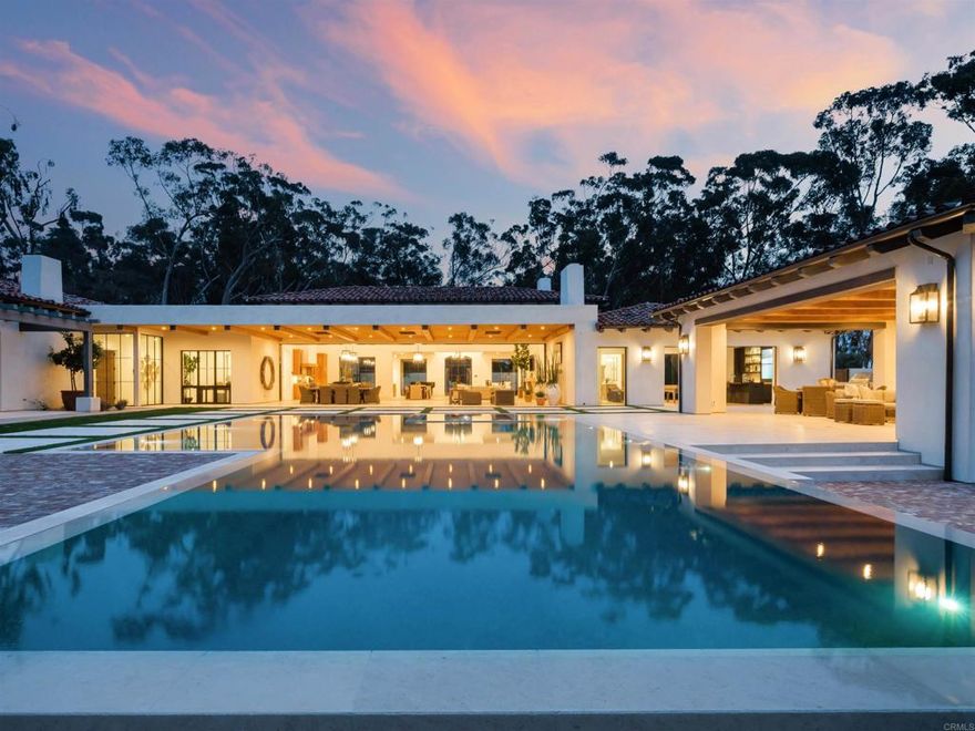 15250 Las Planideras in Rancho Santa Fe is a truly exceptional property. This brand-new custom home, built by award-winning Herbst Construction and designed by Atelier A.Tesselaar, sits on nearly three acres of flat usable land. With 7 bedrooms, a theatre room, a "Kid Wing," chef's and presentation kitchens, wood-burning fireplaces, a climate-controlled wine room, a "Man Cave," a pool cabana, outdoor BBQs, a 6-car garage, herb garden, orchard, and a mini football/soccer field with Bermuda turf, no expense was spared in creating this ultimate family and entertainment home.  Enter through the private gate and drive down the cobble-lined driveway surrounded by olive trees, leading to the tranquil front courtyard with a custom steel glass front door. The expansive great room features French white oak hardwood floors, antique-finished beams, and a 46-foot-long electronic glass sliding door opening to the backyard. Outside, you'll find an outdoor living area paved with Exquisite Surfaces limestone, offering breathtaking views of rolling hills, sunsets, and an 8-foot-deep infinity-edge saltwater pool and spa.  The kitchen is a culinary enthusiast's dream, with top-of-the-line appliances, including a La Cornue range in the front kitchen and stainless steel countertops, Shaw sinks, and a 48' Thermador range in the back kitchen. The master wing exudes luxury with a private courtyard, outdoor shower, and stunning views. The bathroom features a soaking tub, custom sauna, double shower, and exquisite Macchia Vecchia calcutta marble. The master suite also includes two large wardrobe closets, a Miele coffee bar, and a beautiful stone fireplace.  Further down the hallway, you'll discover the kids' wing, complete with a theatre room, entertainment wall, four ensuite bedrooms, and a charming jack-and-jill bathroom. On the south side of the home, you'll find the guest wing with a private entrance courtyard, well-appointed guest room, and a remarkable "Man Cave" featuring an indoor driving range, TVs, and a full commercial bar.  Completing the picture is the inviting pool and spa area with a cabana overlooking the stunning backyard landscape. The 915-square-foot custom pool house is equipped with a kitchenette, BBQ, bathroom, fireplace, TV, and a French limestone fire pit.  Welcome to 15250 Las Planideras, where you'll truly feel at home. Visit www.15250lasplanideras.com for more information.