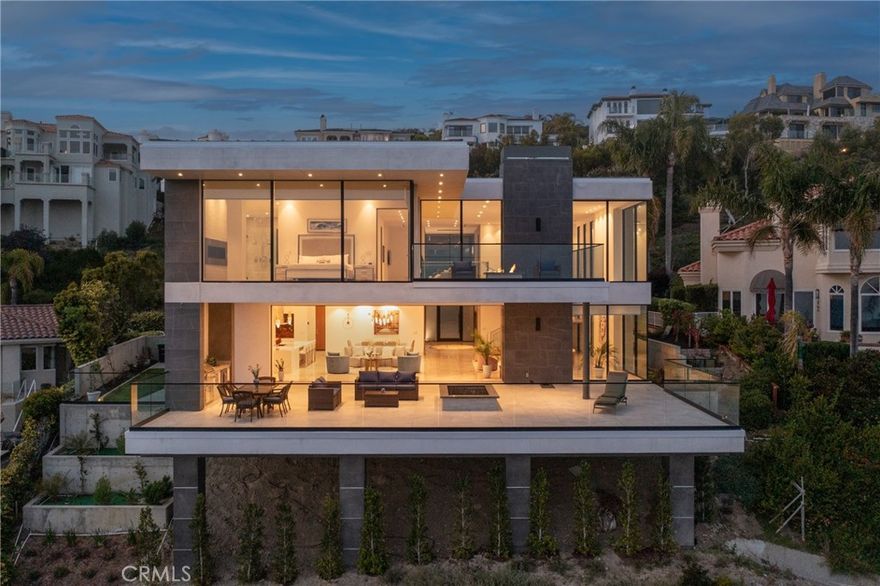 Welcome to 4 Via Cancha. This stunning new construction home designed by the acclaimed Whipple Russell Architects offers unobstructed 180-degree panoramic ocean views spanning from San Diego to Dana Point. Perched atop a premium hilltop lot in the exclusive 24-hour guard-gated community of Sea Pointe Estates, this modern home provides ultimate privacy and security. As you enter through the pivot front door you are greeted by the expansive 5742 sq ft living space with 23-foot-high ceilings and a fireplace spanning two stories. The extra spacious back deck seamlessly opens into the living space creating an indoor/outdoor feel that is perfect for Southern California living, watching the sunset over the ocean. The fire pit provides additional outdoor entertainment options. Curated with distinctive high-end designer finishes, the 5 bedroom, 5 ½ bathroom home boasts top quality master craftsmanship including 9-foot walnut interior doors, European Oak floors upstairs, and an open concept designer kitchen with a back kitchen for food prep. The 16-foot long quartz waterfall kitchen island and built-in Thermador appliances make it the perfect place for hosting guests or preparing gourmet meals. The luxurious master suite features a fireplace, Cambria quartz countertops, double vanity, a sleek freestanding bathtub, and an oversized shower and walk-in closet. Step out onto the balcony with a fire pit and take in the breathtaking views while enjoying the warmth of the fire. Floor-to-ceiling windows throughout the home provide ample natural light and highlight the exquisite attention to detail found throughout the home. The built-in BBQ and wine and beverage chiller are perfect for outdoor entertaining, while the 3-car garage provides ample storage space for all your vehicles and toys. Amenities of Sea Pointe Estates include a swimming pool, spa, tennis courts and clubhouse. This home is perfect for anyone looking for comfortable California coastal living. ***Also available furnished for​​‌​​​​‌​​‌‌​​‌​​​‌‌​​​‌​​‌‌​​​‌​‌​​​‌‌​ $25,000/month***