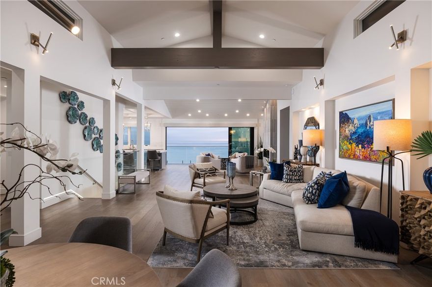 Enrich your lifestyle with this nearly new custom contemporary showplace crowning a bluff in Dana Point, where 180º unobstructed front-row ocean views embrace crashing waves, Catalina Island sunsets, and evening-light views. Entertain in a spacious backyard overlooking Capistrano Beach as guests enjoy watching surfers challenge the waves, and majestic yachts and colorful sailboats glide in and out of Dana Point Harbor. Dana Point’s Headlands frame the view to the north, while San Clemente lies to the south. Completed in 2020, the five-bedroom, five-bath design of approximately 4,454 square feet presents an open-concept design that allows most rooms to welcome the property’s views, which are visible upon arrival through a glass entry door. The foyer leads to a vast living space with a lounge area, dining room with glass-enclosed wine room, and a family room with linear fireplace and slide away glass doors leading to an ocean-view balcony. Vaulted and coffered ceilings embellish this level, which also includes an island kitchen with quartz countertops, Thermador appliances including a built in coffee/expresso machine, Shaker cabinetry, full house soft water filtration system, and a butler’s pantry. The home lives like a single-level design by placing the primary suite on the main floor as well as 3 guest bedrooms. Homeowners will appreciate this suite’s domed tongue-and-groove ceiling, a romantic ocean-view balcony, linear fireplace, walk-in closet, LED mirrors, a freestanding tub and a multi-head shower. Enjoy indoor/outdoor entertaining downstairs, where a versatile bonus room with walk-in wet bar opens to the backyard, which allows ample room for a future pool, spa and outdoor kitchen. A guest suite or home office also boasts direct access to the outdoors. Curb appeal is unmatched with an attractive three-car garage and a paver-finished circular driveway that accommodates three. Located in The Palisades of Capistrano Beach, this luxurious home is close to miles of sandy beaches, Palisades Gazebo Park, excellent schools for all grade levels, harbor shops and restaurants, and Dana Point’s popular Lantern District.