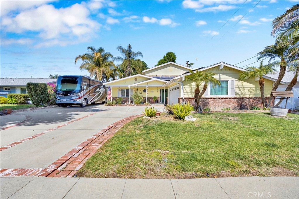 Welcome to this spacious 4 bedroom, 3 bathroom residence boasting over 2,500 square feet of living area. Enjoy the benefits of a fully paid solar system, featuring 48 panels generating 10.4 kilowatts of power, complemented by 2 Tesla backup batteries. The home is equipped with copper plumbing, dual-pane windows, and dual-zone A/C controls for both levels of the home. Security is enhanced with pre-wired camera connections. The kitchen has been tastefully upgraded with soft-close drawers and cabinets, a Corian island counter, and stainless steel appliances. Retreat to the expansive 625-square-foot master suite, complete with a luxurious bathroom featuring a spa tub, a generous walk-in closet, and its own relaxing patio deck. Both downstairs bathrooms have been recently remodeled. Throughout the home, you'll find LED recessed lighting, ceiling fans, and plantation shutters. The living room and master bedroom are pre-wired for surround sound, and the entire house is wired for network. Ample storage solutions include a garage attic, an under-stairs closet, two second-floor attics, and a nearly 225 square-foot backyard shed. Step outside to a backyard oasis with a fire pit, water feature, newer vinyl fencing, AstroTurf, and flagstone grounds, all with a large covered patio with speakers. The property also offers substantial RV parking with dedicated electrical and sewage connections. A split water meter system helps reduce DWP sewage costs by separating home and gardening usage. Automatic sprinklers, and automatic low voltage lighting. Conveniently located near multiple malls and restaurants, the LA Rams training facilities, and the ambitious Warner Center redevelopment project; this home combines comfort with prime accessibility.