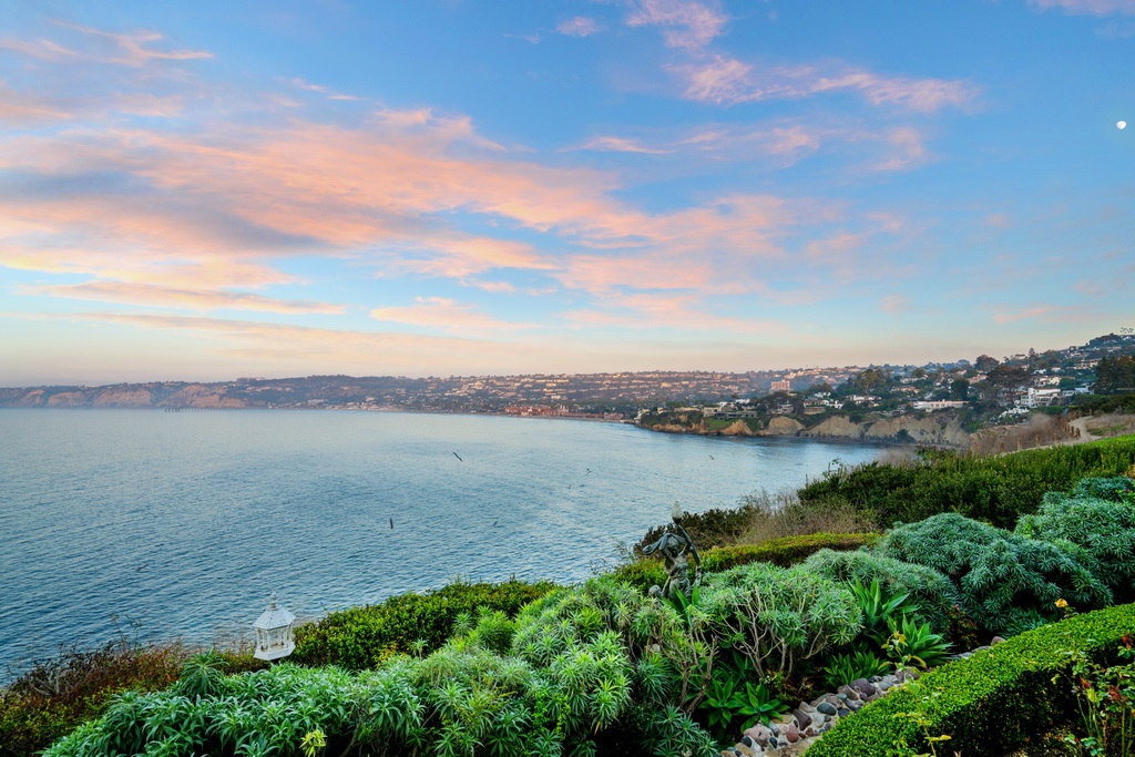 Ideally located in the heart of the Village is this iconic gated Hamptons-style estate that has been meticulously upgraded yet has kept all the architectural integrity of its wonderful past. The Seacliff Estate was perfectly placed on this private bluff above La Jolla Cove to capture the most enchanting ocean and coastline views, spanning from La Jolla to Dana Point while being just steps away from the magic of downtown La Jolla. Through the gates, you will find a 2 BR, 2.5 BA two-story guest house... complete with a living room with fireplace, kitchen, 2-car garage, magnificent viewing balcony, and convenient street/sidewalk access. A short drive past the pool brings you to the main house, where you are welcomed through the doors to a formal entry, complete with a grand staircase. The expansive living/dining area opens onto the glassed-in porch and view terraces, offering plenty of room for entertaining and ideal indoor/outdoor living. The large chef’s kitchen and breakfast area can be found at the other end of the view terraces and includes double doors for easy access. Completing the main level are the library and two offices. An elevator or staircase leads you to both the second level and the informal entertaining level. The master suite located on the second level enjoys the same panoramic views of the vast blue sea and coastline and includes a fireplace, separate his and hers bathrooms with natural lighting, generous walk-in closets, and private viewing deck. The entertaining level is complete with a recreation room, bar, wine cellar, wine tasting room, theater, exercise room, laundry room, and additional decks. No details were spared in the construction of Seacliff where privacy, luxury, and comfort come together perfectly. Square footage and BR/BA count includes guest house.. Neighborhoods: Village Equipment: Dryer,Pool/Spa/Equipment, Washer Other Fees: 0 Sewer: Sewer Connected Topography: LL Frontage: Ocean/Bluff