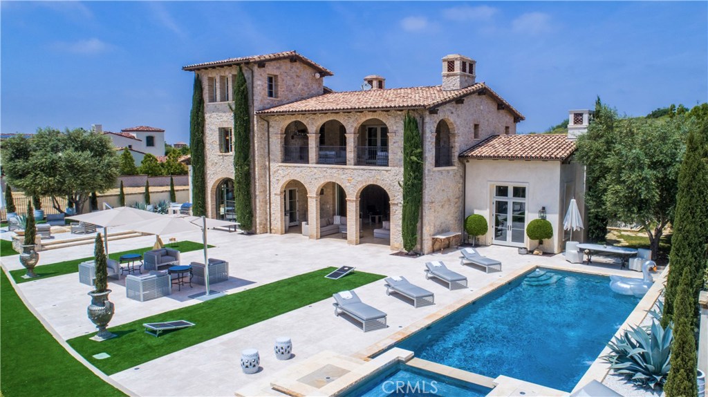 This magnificent Italian-inspired estate evokes the splendors of the Tuscan countryside in Orange County’s premier, guard-gated golf community of Shady Canyon. A perfect landscape characterized by rolling hills, discover all the natural beauty this 5 bedroom, 8 bathroom custom-built architectural masterpiece has to offer. From imported stone walls, reclaimed wood beams, stainless steel, and brick throughout combined with the modern luxury of smart technology and modern conveniences, this astounding 10,600 sq. ft. estate was designed on over 23,000 sq. ft. of lush grounds. Satisfy your culinary delights in the award-winning kitchen with Calacatta marble waterfall counter tops, Wolf appliances and two Sub-Zero refrigerators with open space into the nook and the great room. The luxurious master suite will indulge your sensibilities with the wood beamed ceilings, private balcony, spa like bathroom, dual fireplaces, and two walk-in closets that highlight style and functionality. The loggia, supported by a series of stone and brick arches, provides the perfect blend of outdoor space, flowing seamlessly from the interior to the expansive backyard with all its lavish amenities including a salt-water pool, spa, built-in BBQ & firepit, outdoor shower, natural stone hardscape, and synthetic turf. Additional rooms include a game room with bar, fitness center, wine cellar, theater with 14 ft. viewing screen, Butler’s pantry, and 2 fully appointed laundry rooms. Bellisima!